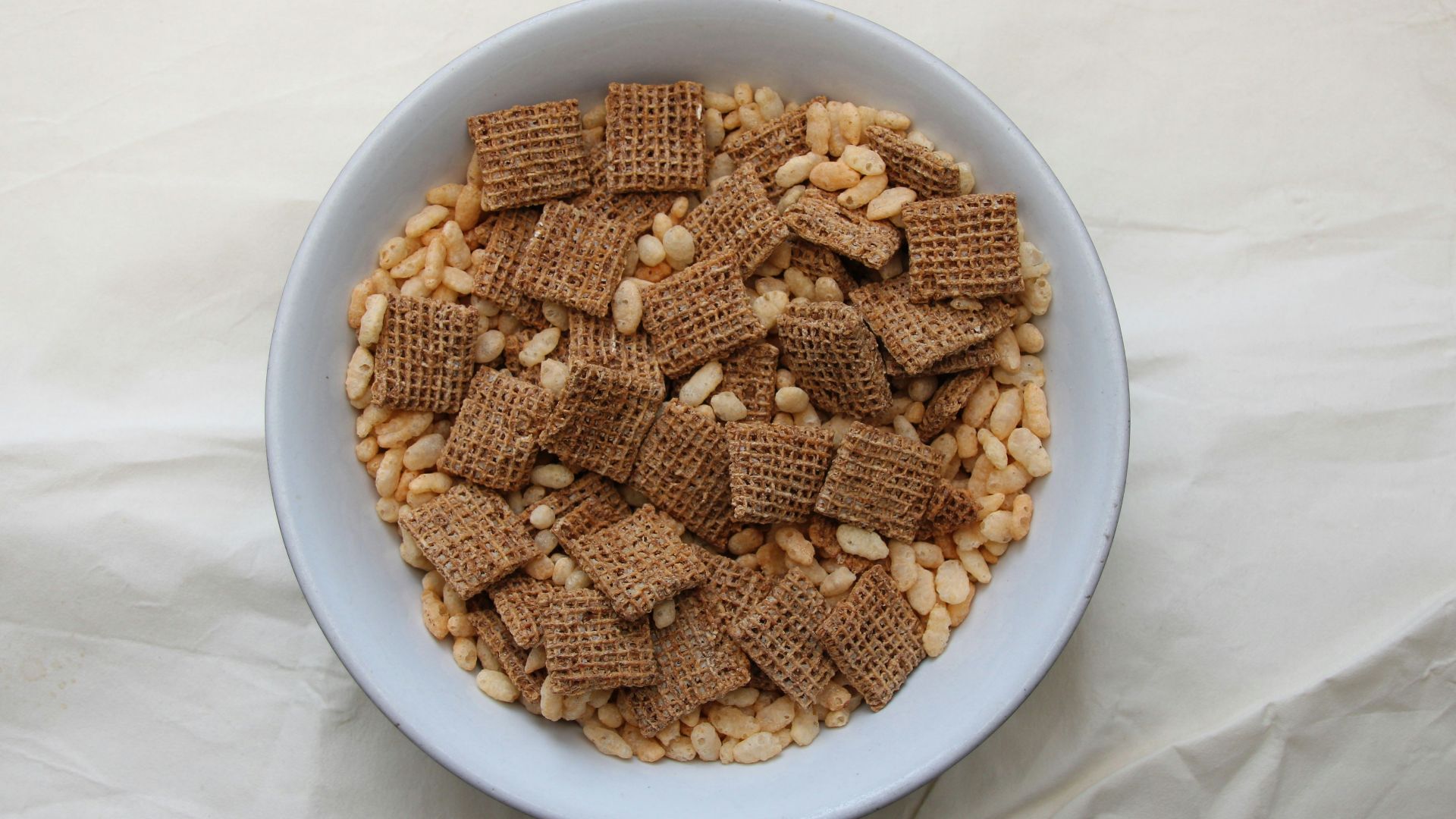 a white bowl filled with cereal on top of a white table