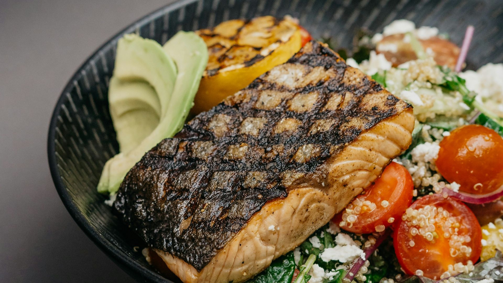 grilled meat with green vegetable on black ceramic plate