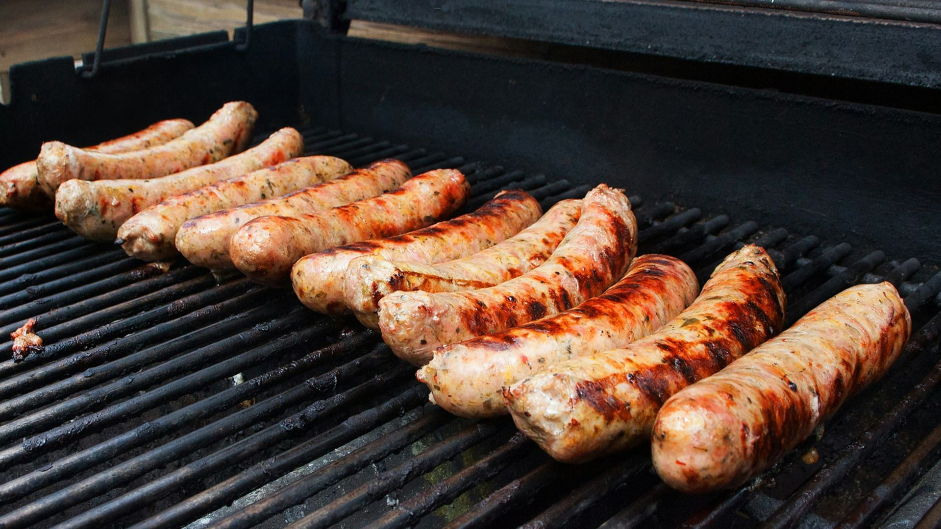 a bunch of sausages are cooking on a grill