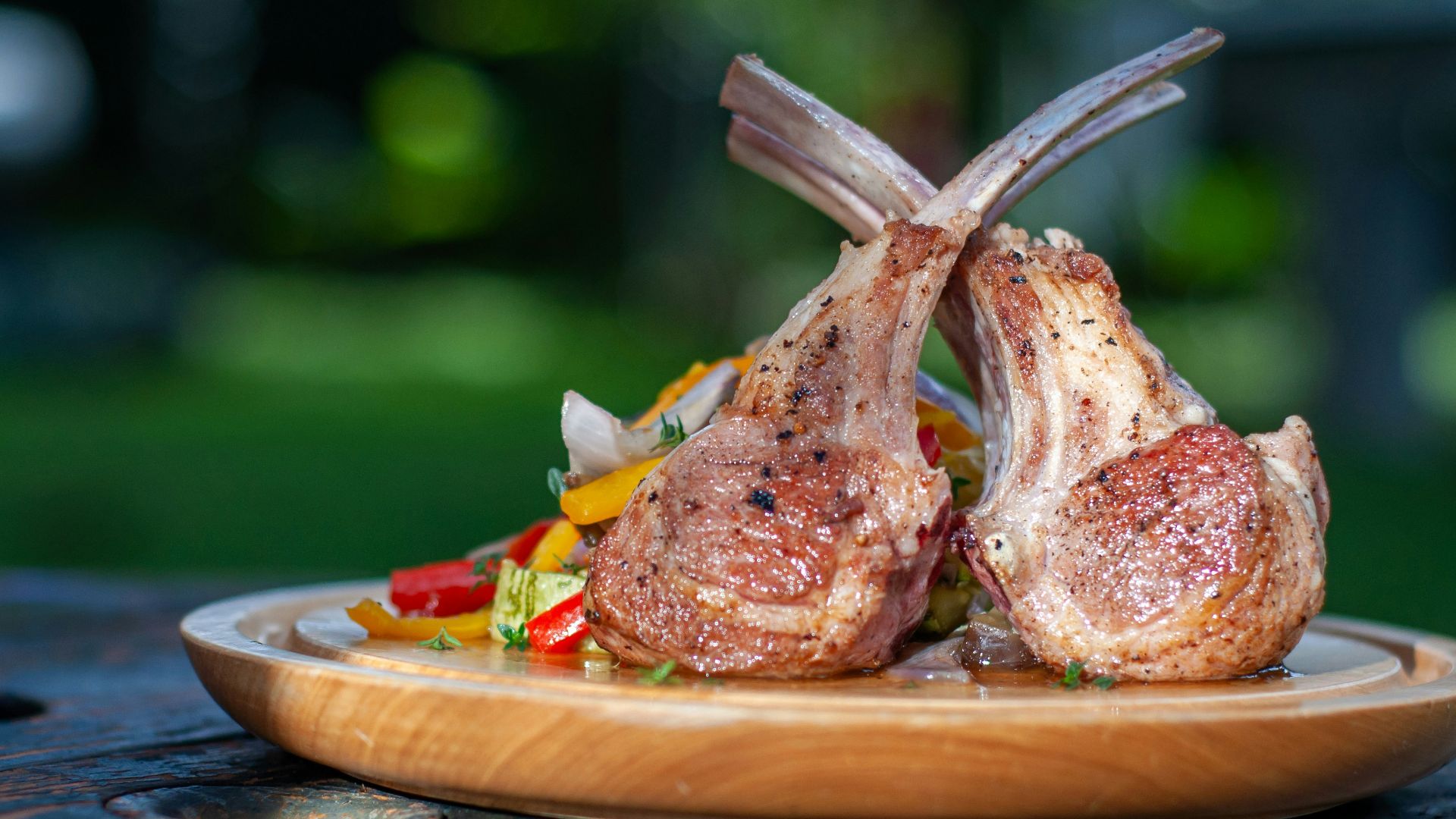 a wooden plate topped with meat and vegetables