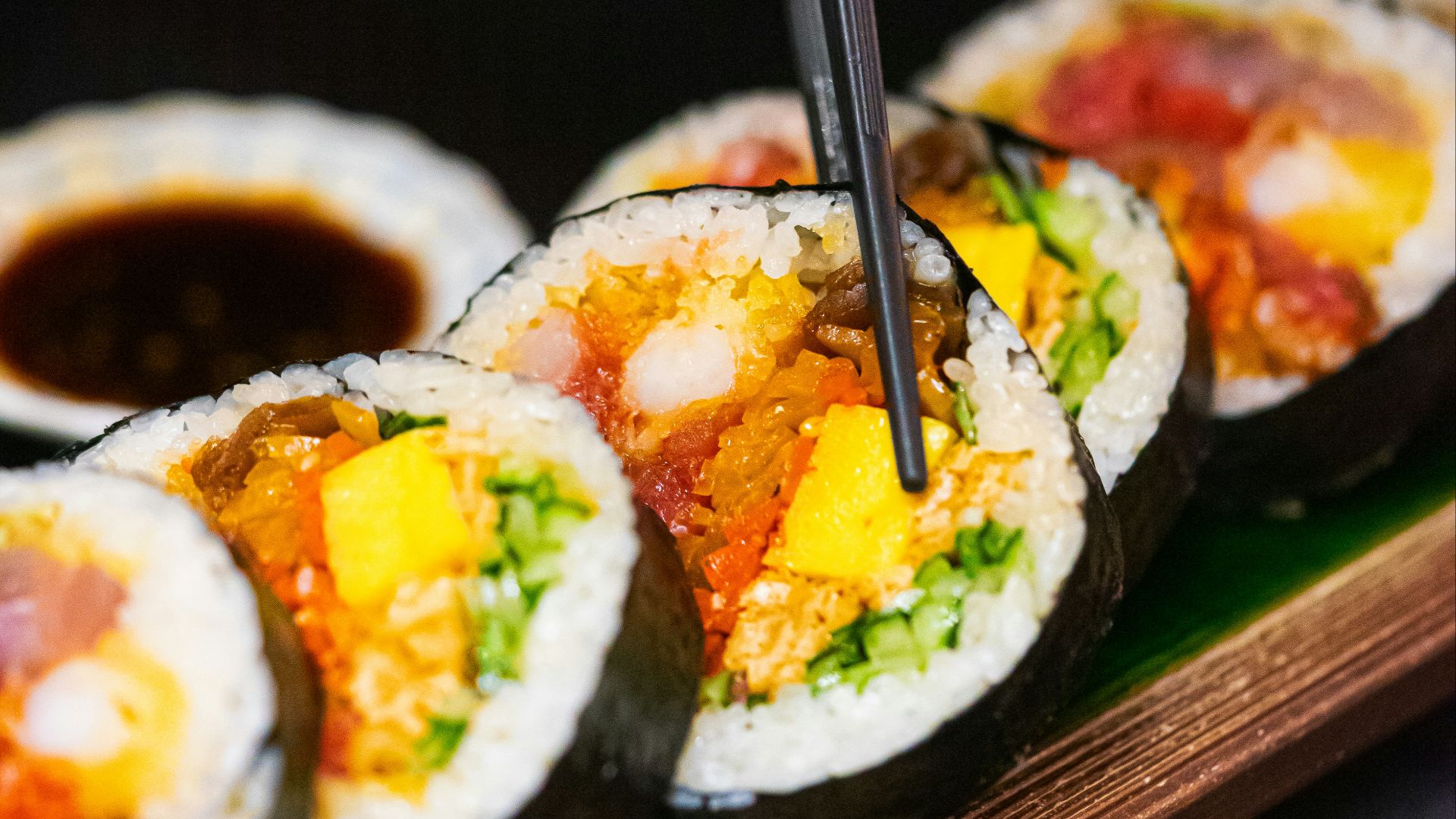 a person cutting into a sushi with chopsticks