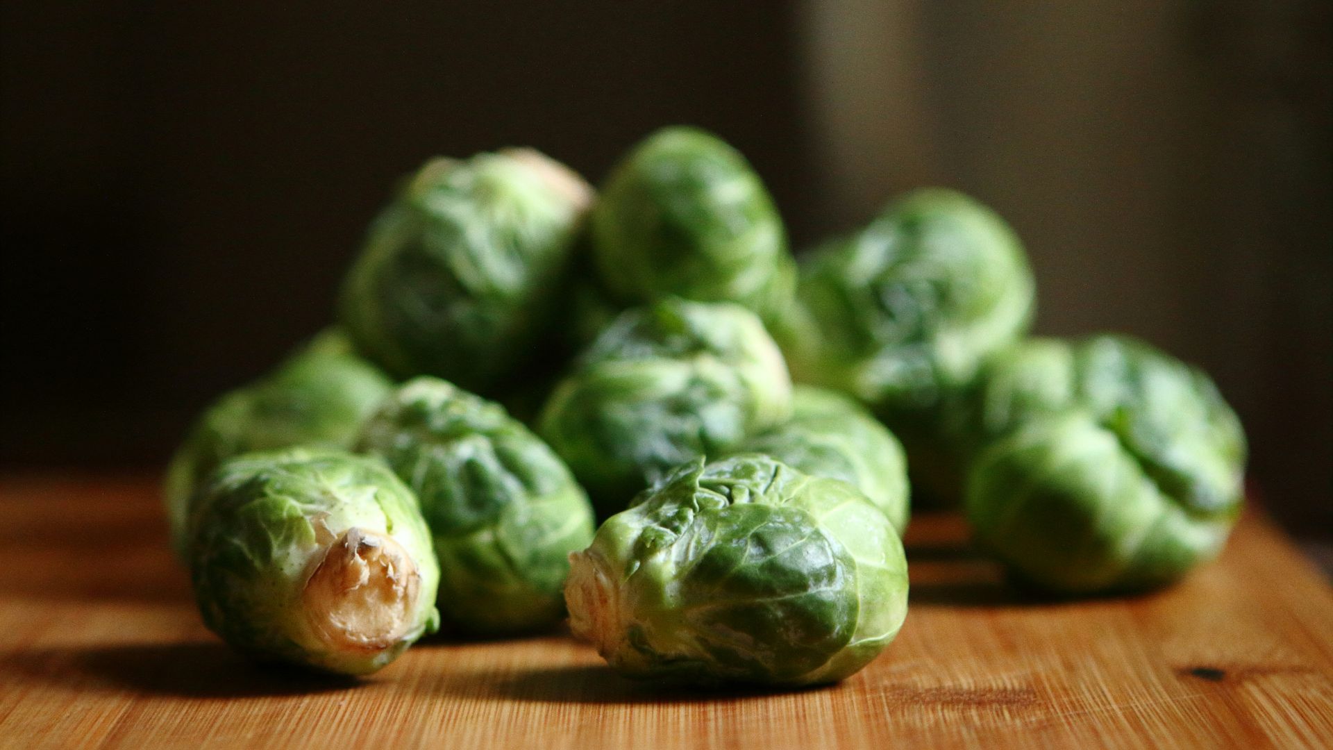 shallow depth of fields photography of green vegetable on brown wooden panel