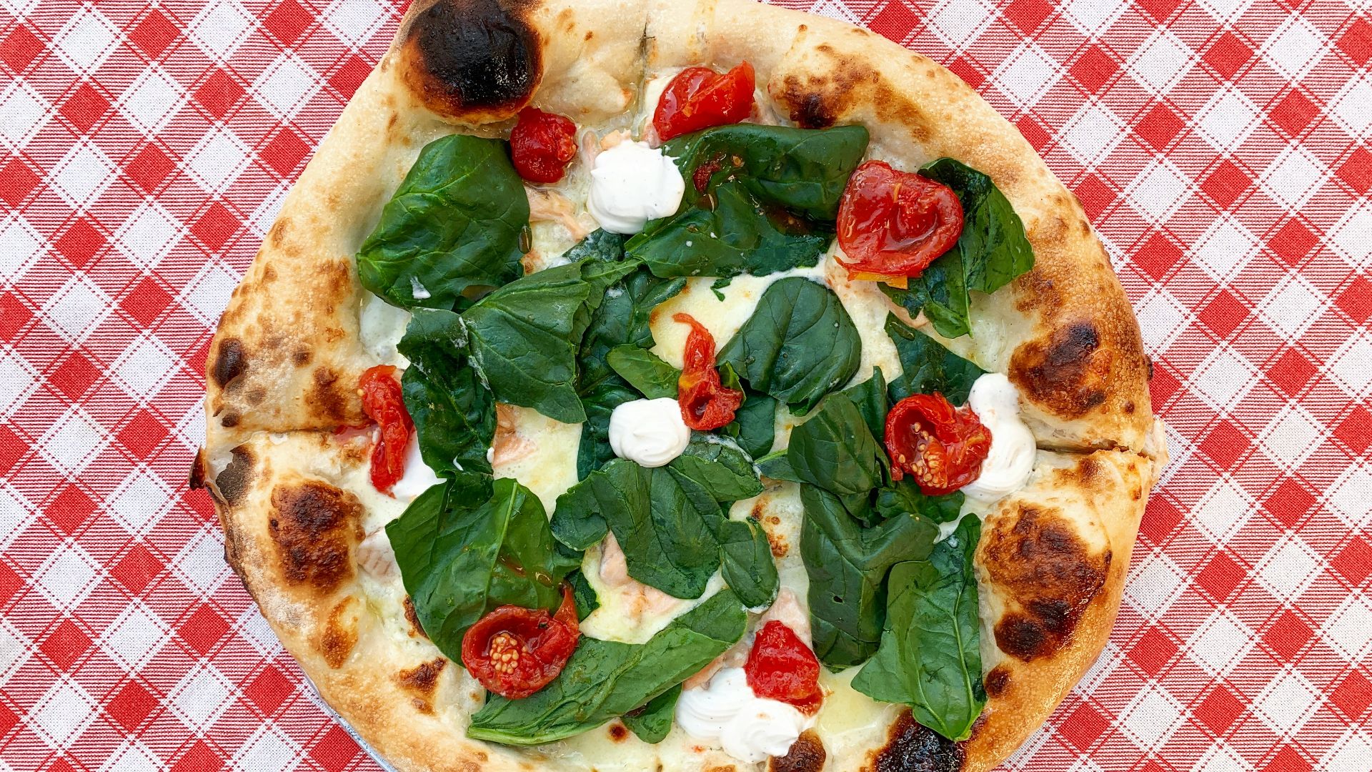 pizza with green leaves on white ceramic plate