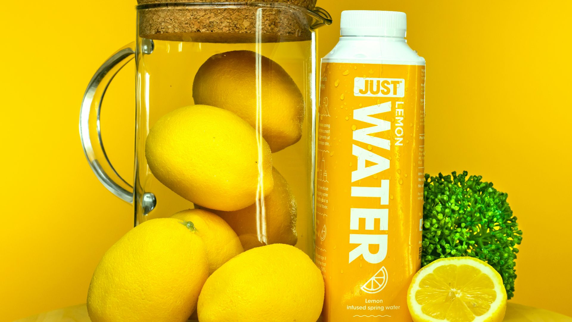 a bottle of oil next to lemons and a lemon