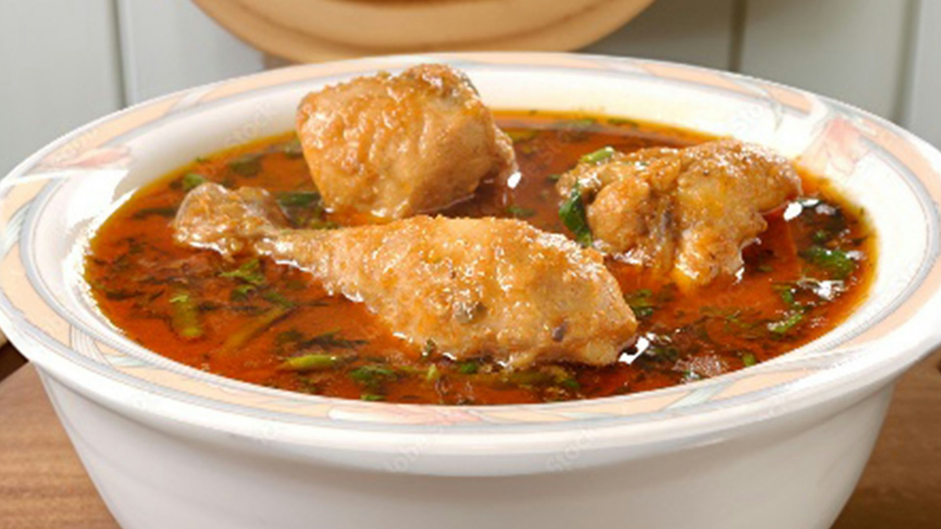 a bowl of soup with meat in it on a table
