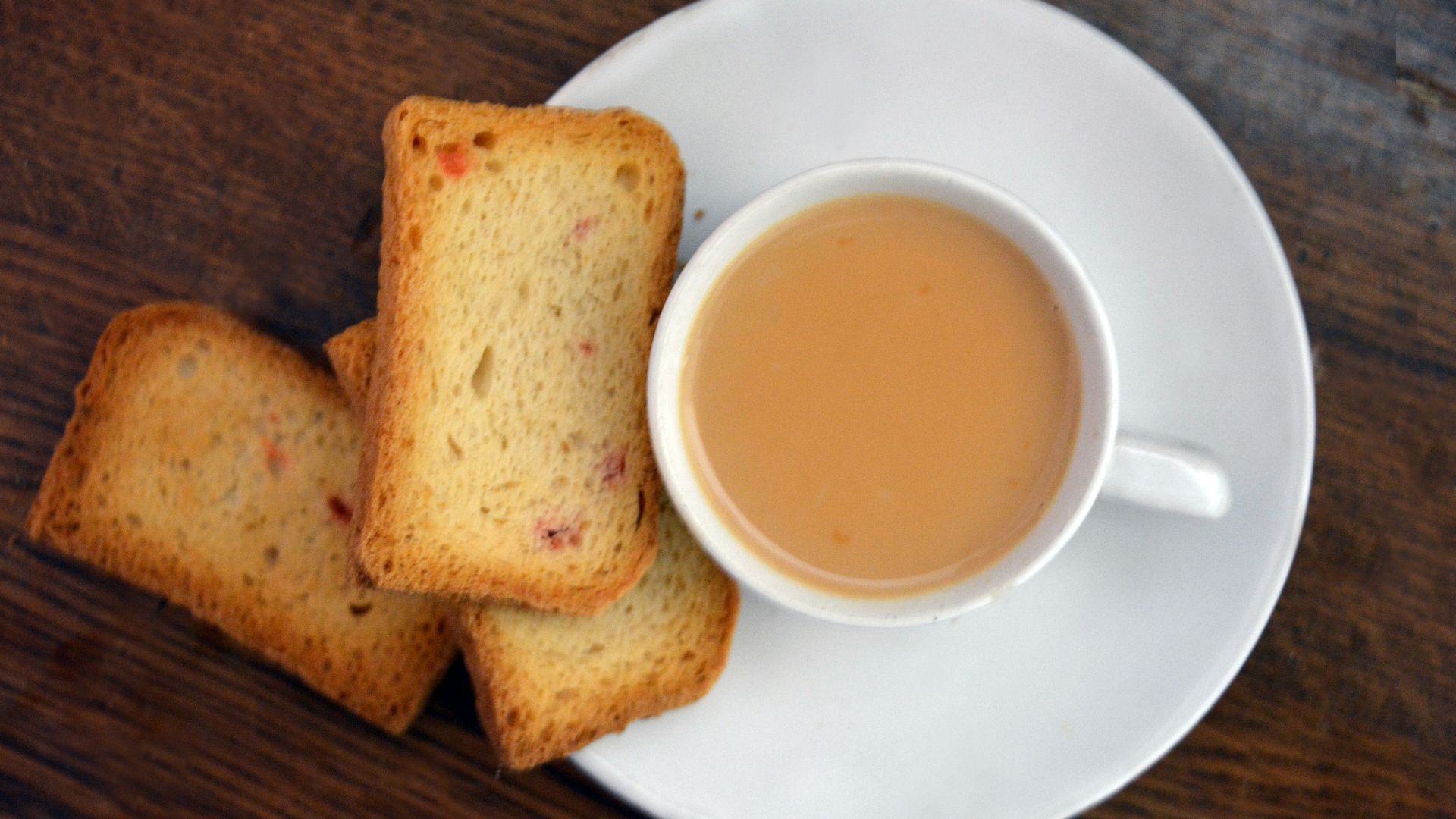 a white plate topped with slices of bread next to a cup of tea