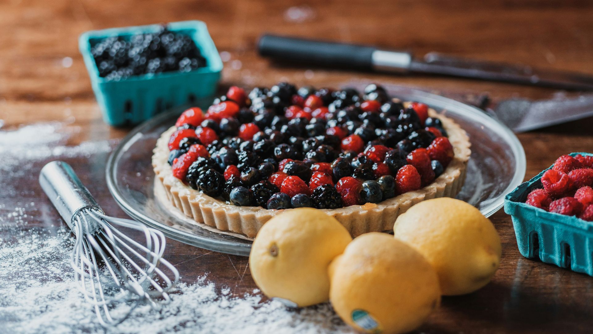 a tart with berries and lemons on a table