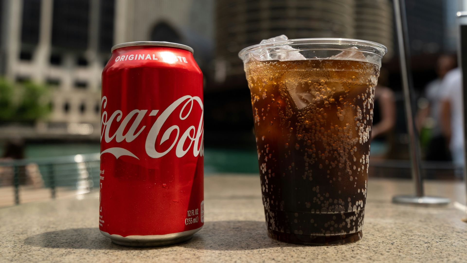 Coca-Cola soda tin can and cup on table close-up photography