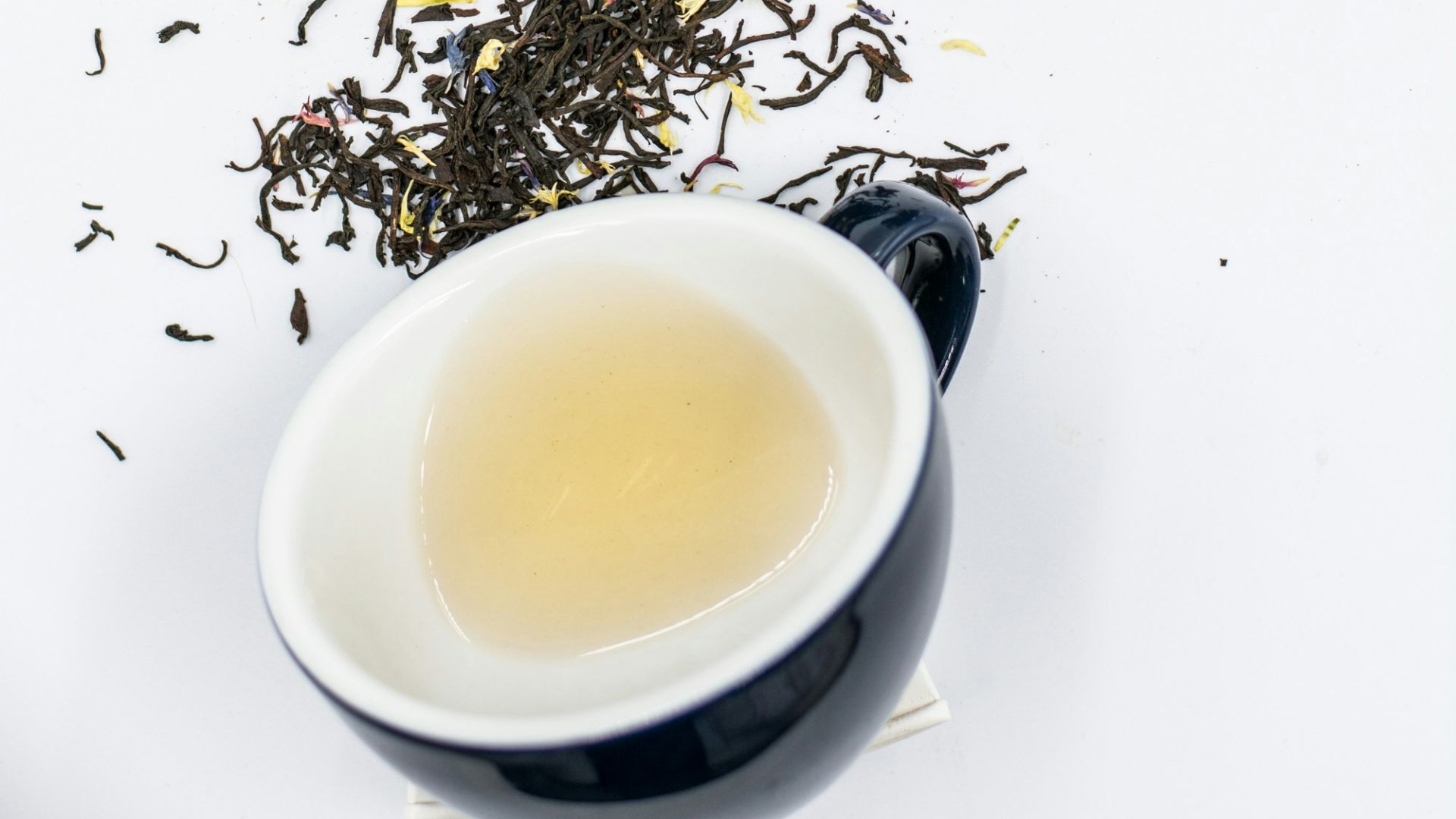 black ceramic teacup on white surface