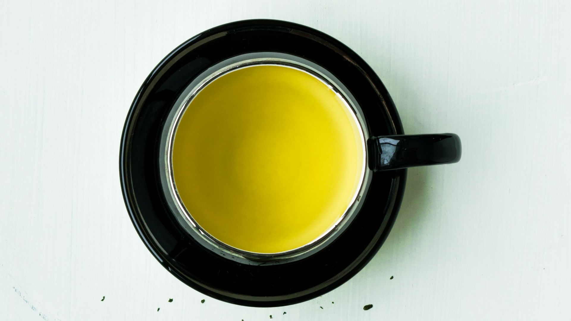 black ceramic mug with brown liquid inside