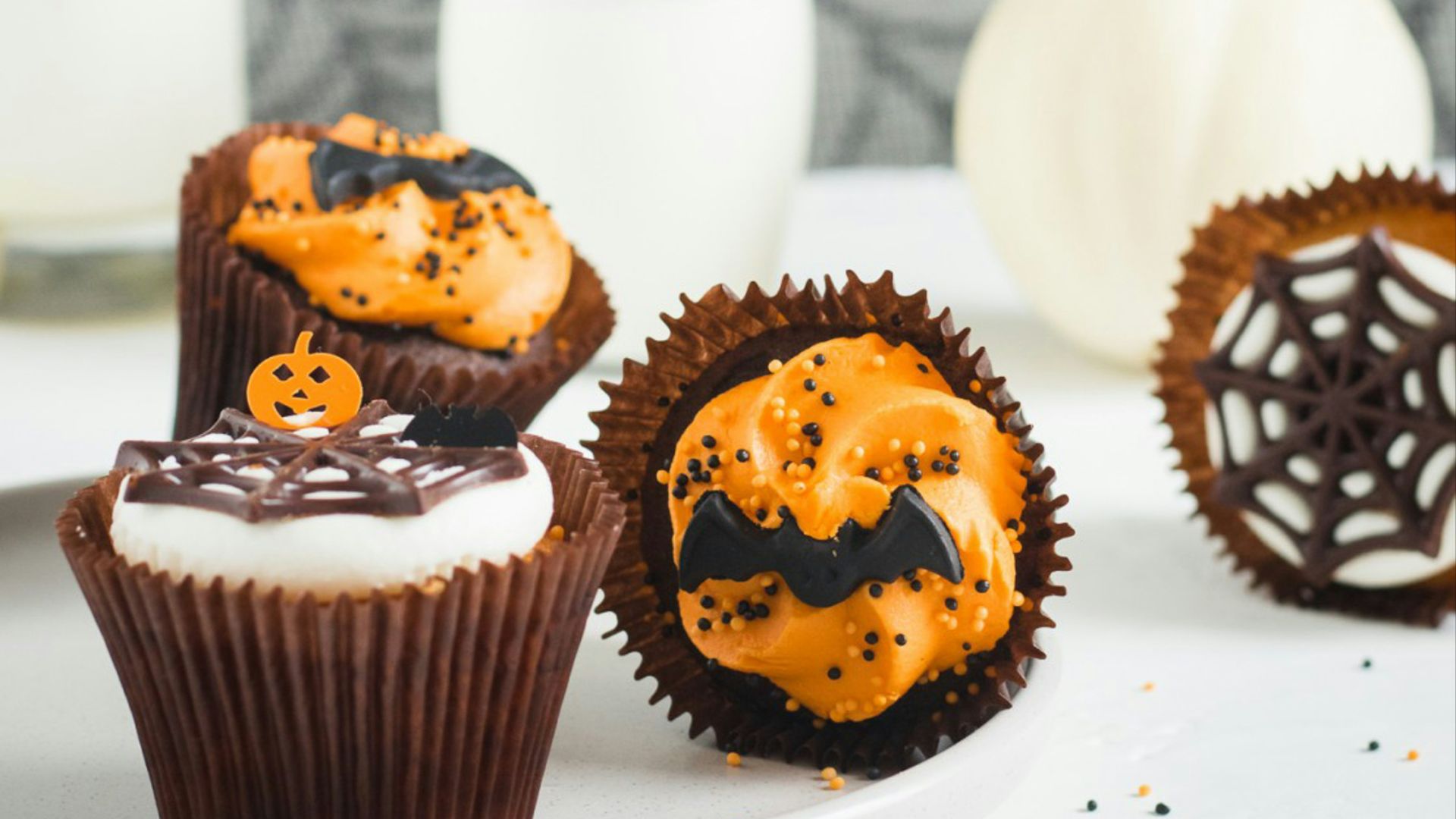 a white plate topped with cupcakes covered in frosting