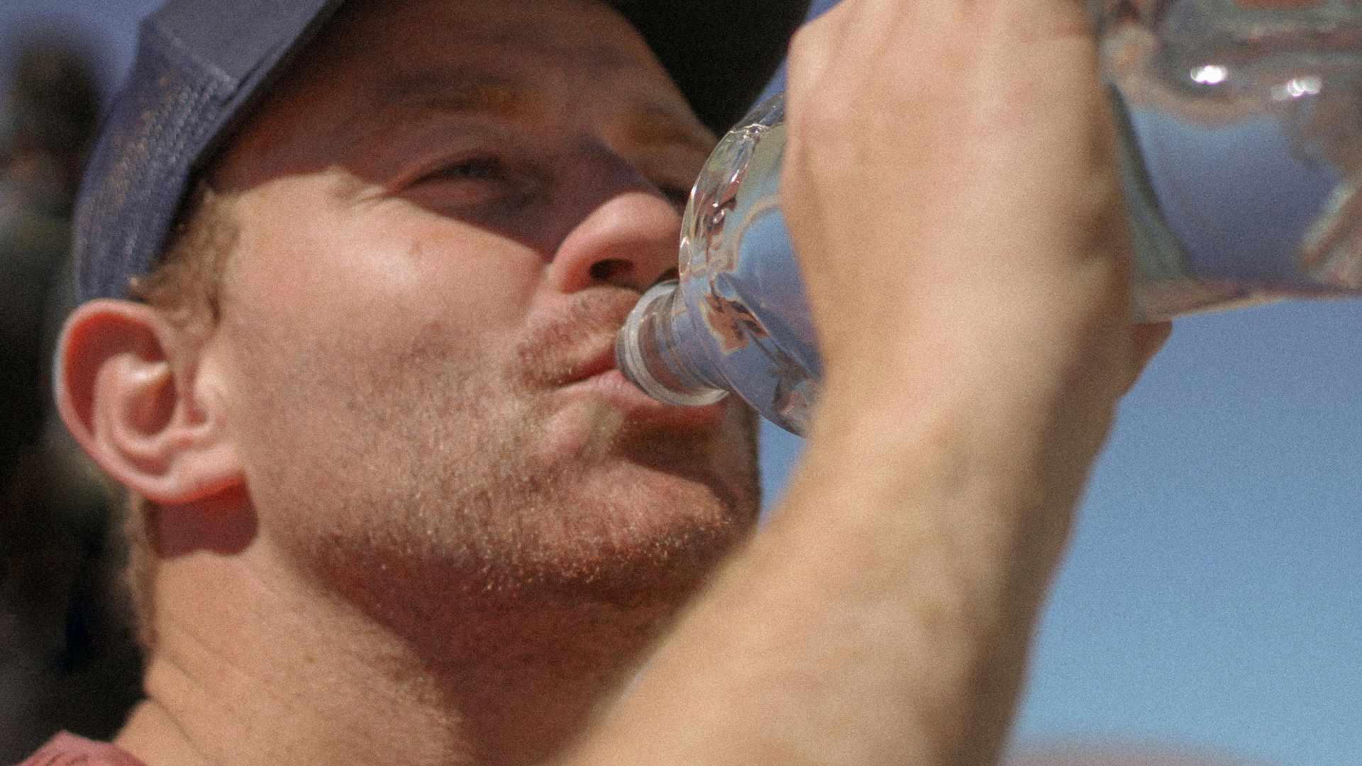 a man drinking water out of a bottle