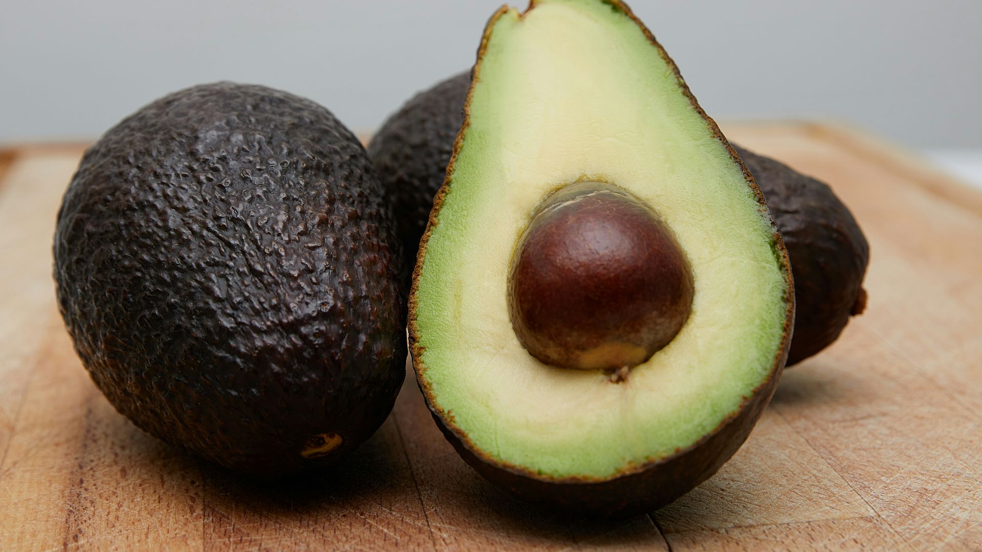 sliced avocado fruit on brown wooden table