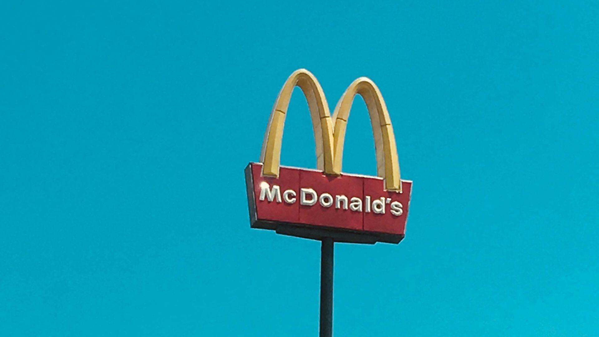 a mcdonald's restaurant sign in front of a blue sky
