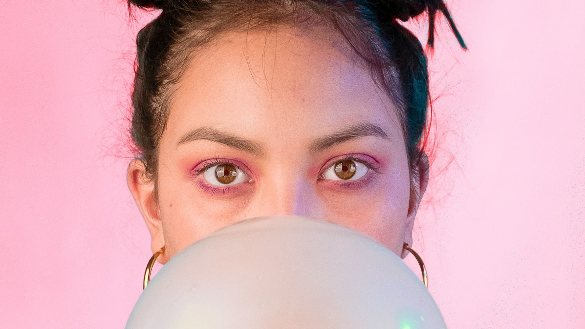 woman in yellow sleeveless shirt blowing gum