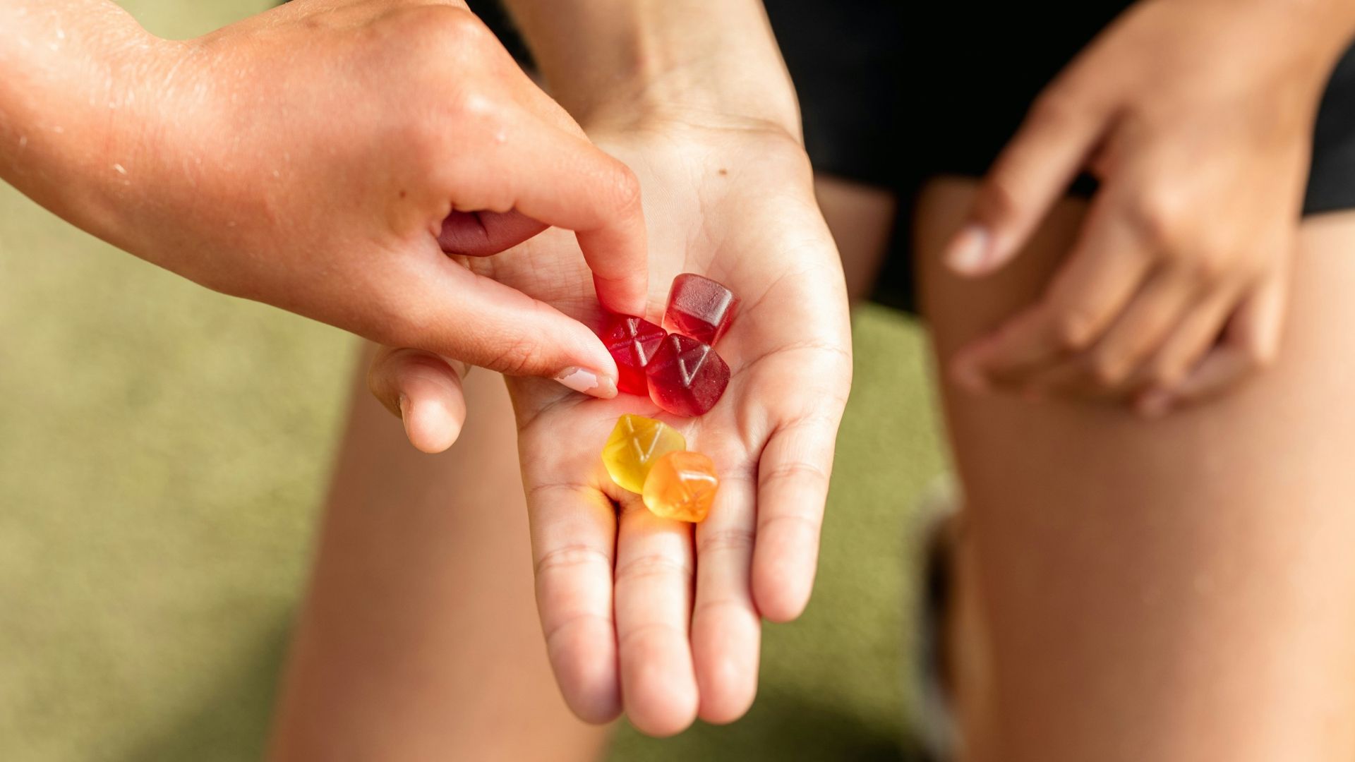 person holding orange and red beads