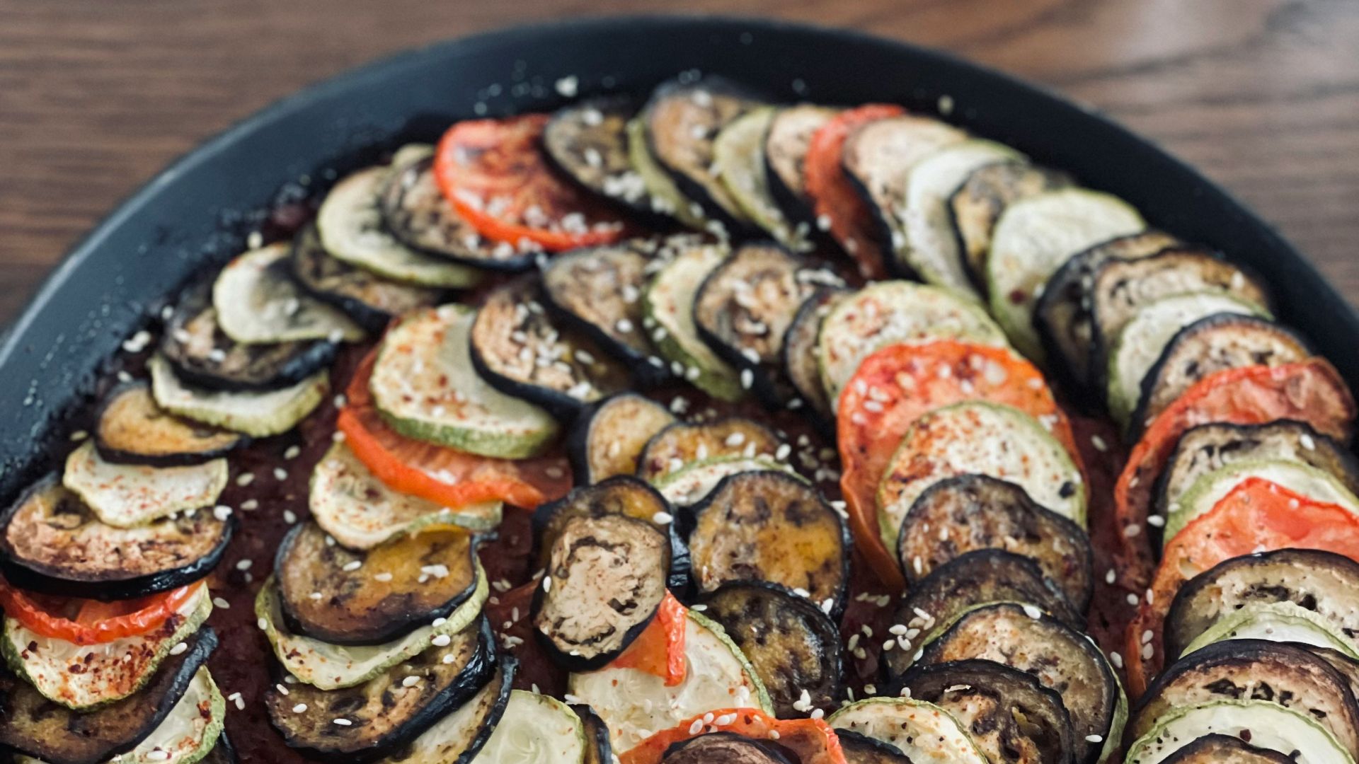 a pan filled with sliced up vegetables on top of a wooden table