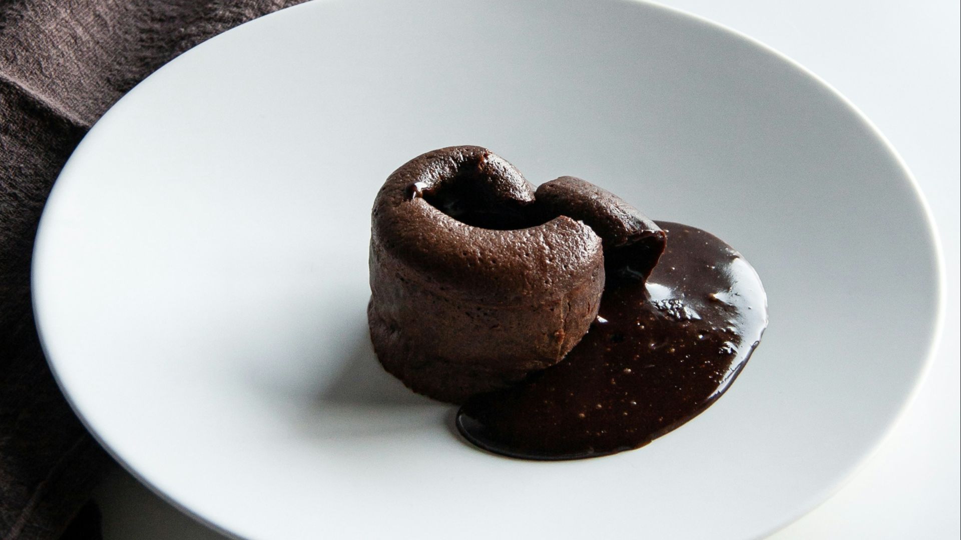 a white plate topped with two chocolate donuts