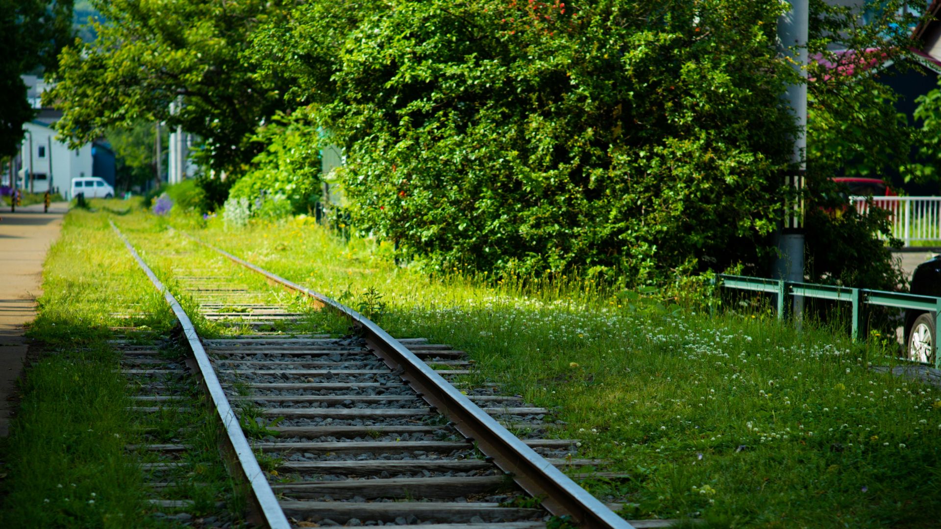 A train track with trees and buildings in the background