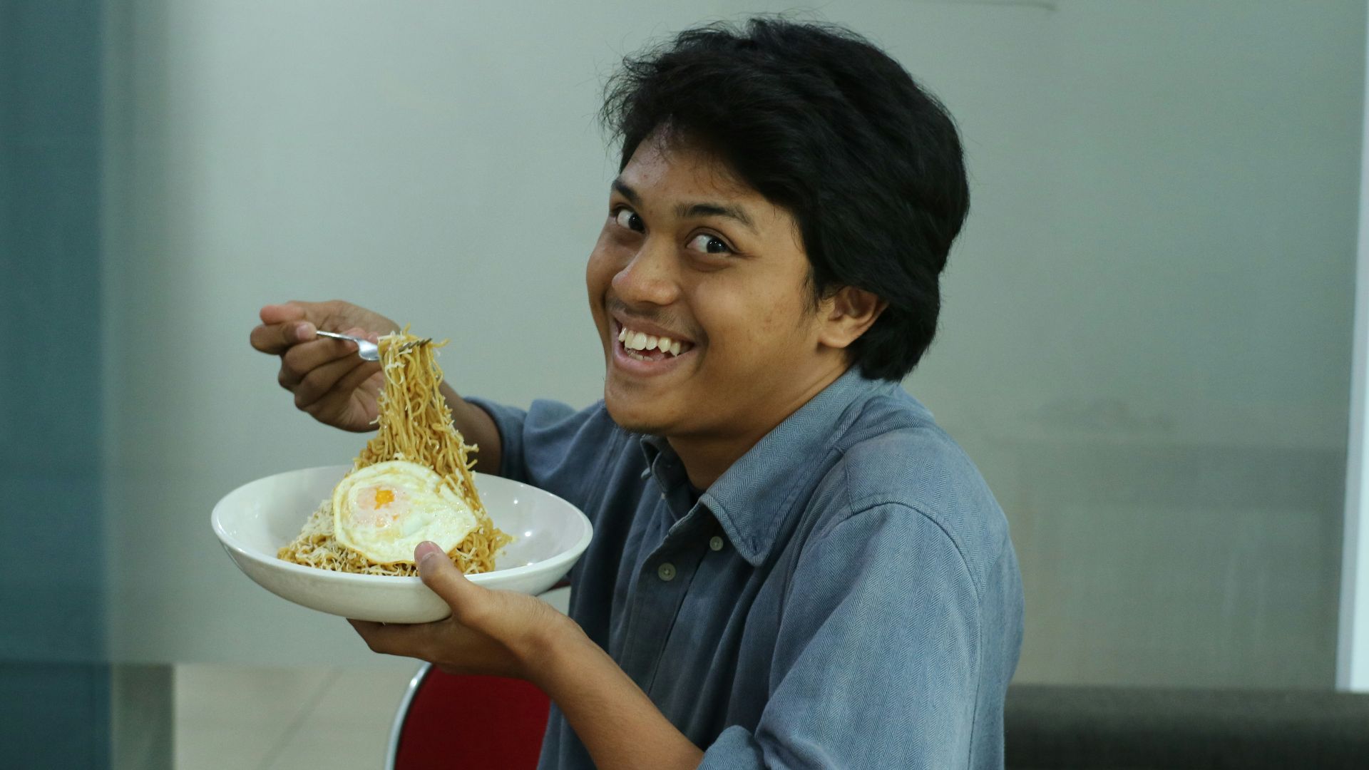 man wearing blue dress shirt holding round white bowl