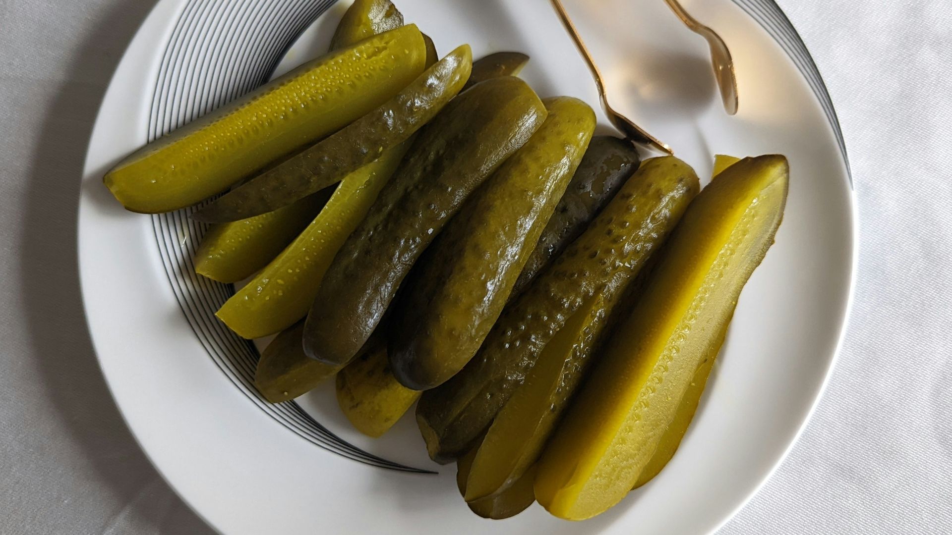 a white plate topped with pickles next to a fork