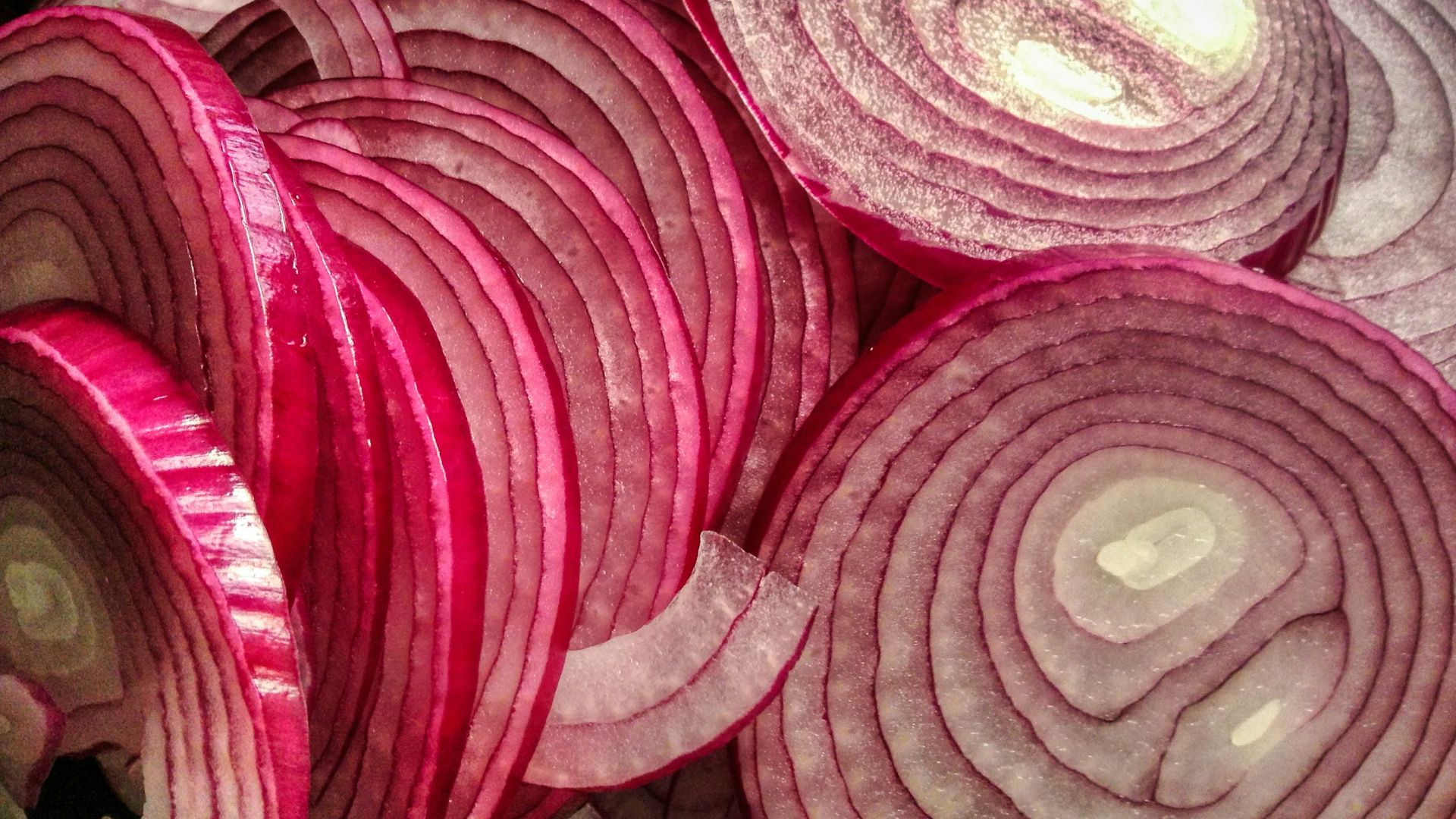 A pile of red onions sitting on top of a table