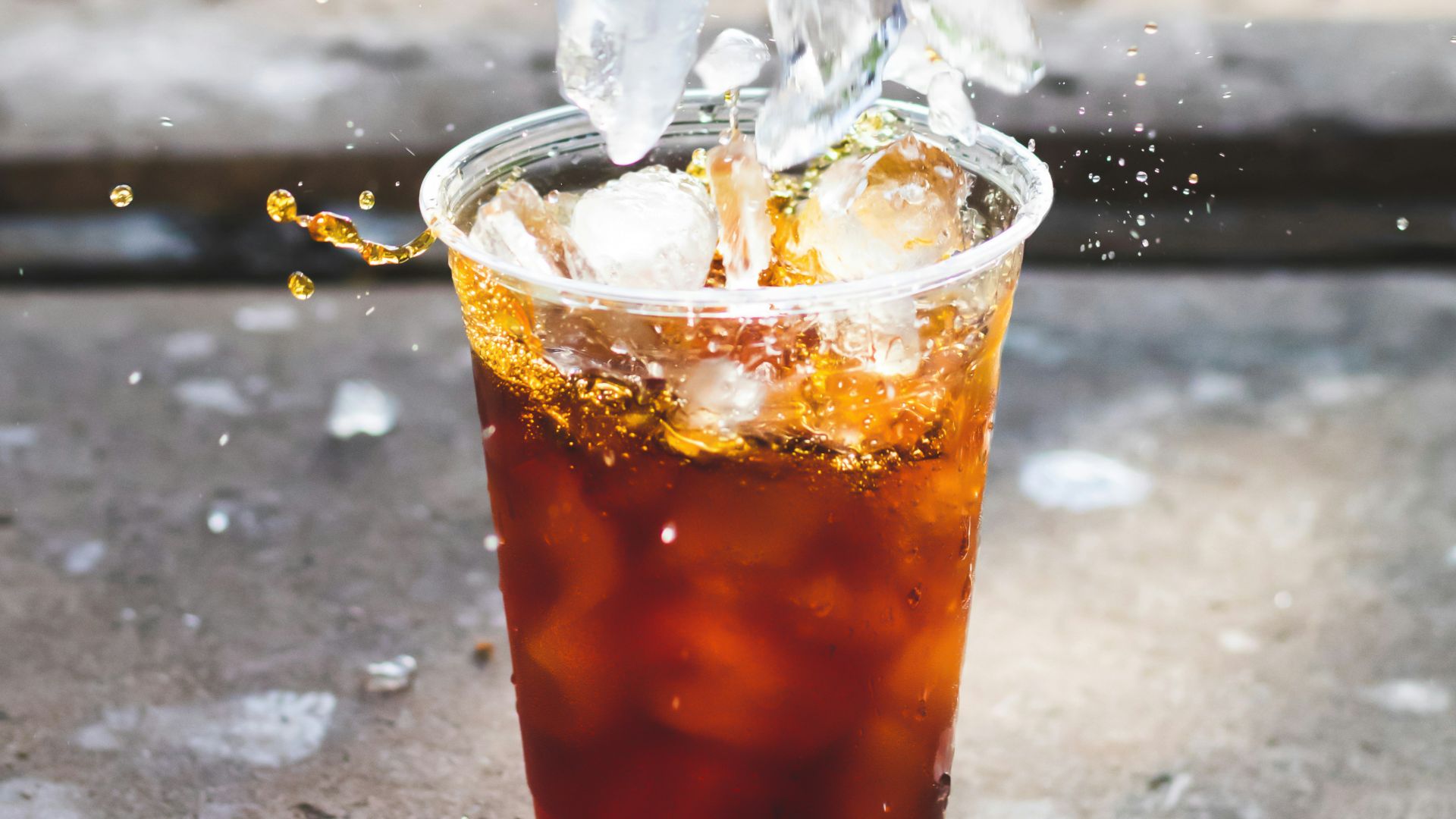 macro photography of dropping ice cube in cup