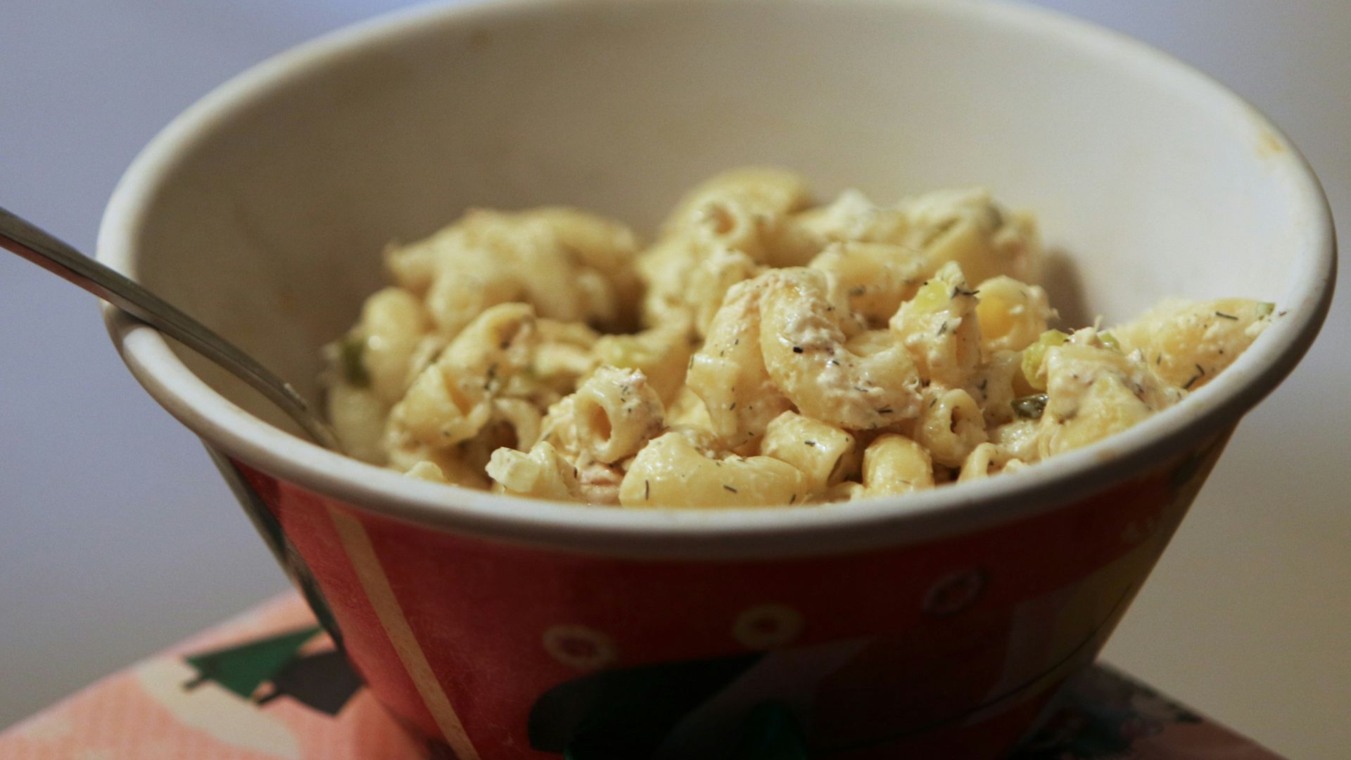 a bowl of macaroni and cheese with a spoon in it