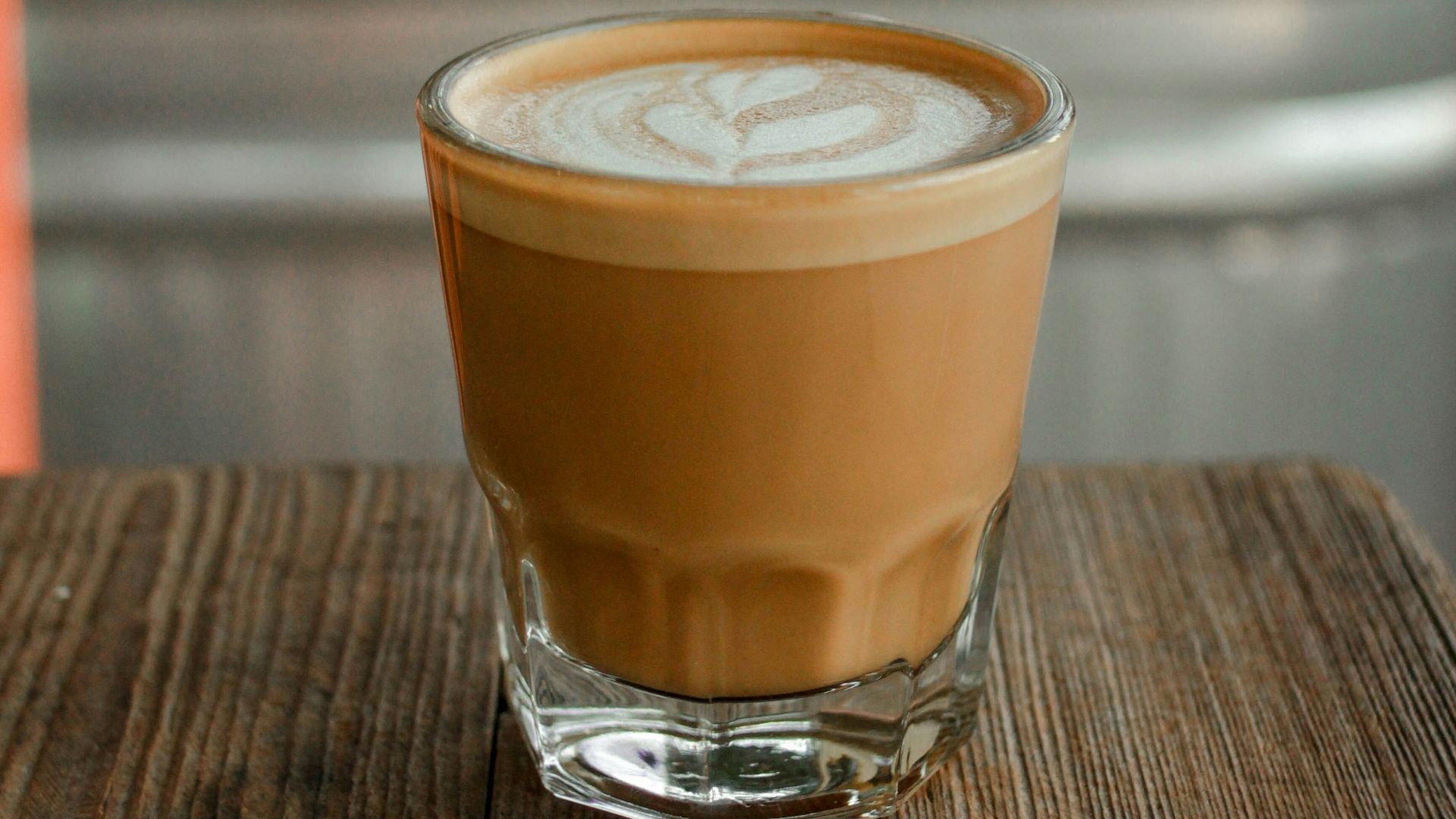 clear drinking glass with brown liquid on brown wooden table