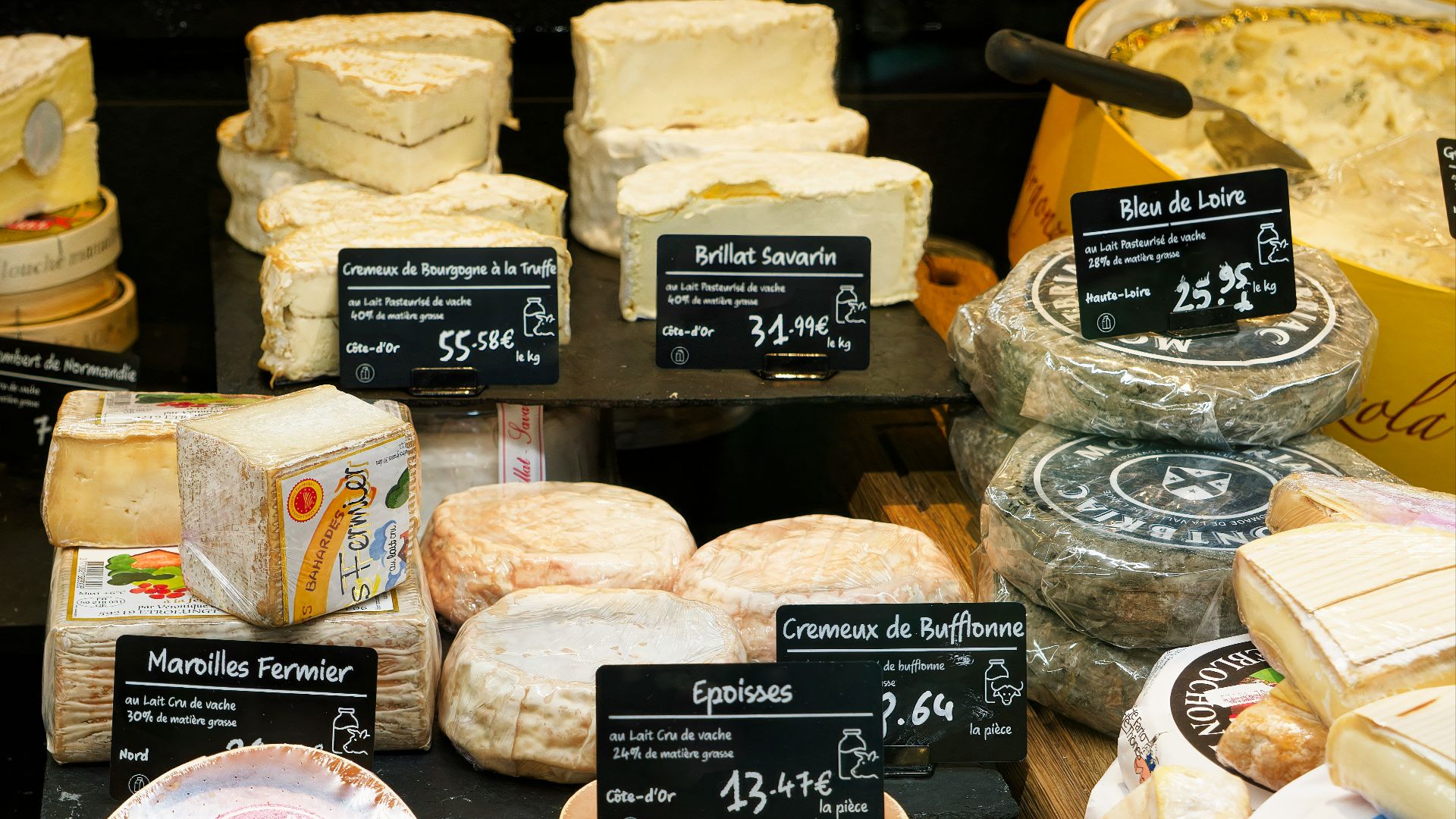 A display case filled with lots of different types of cheese