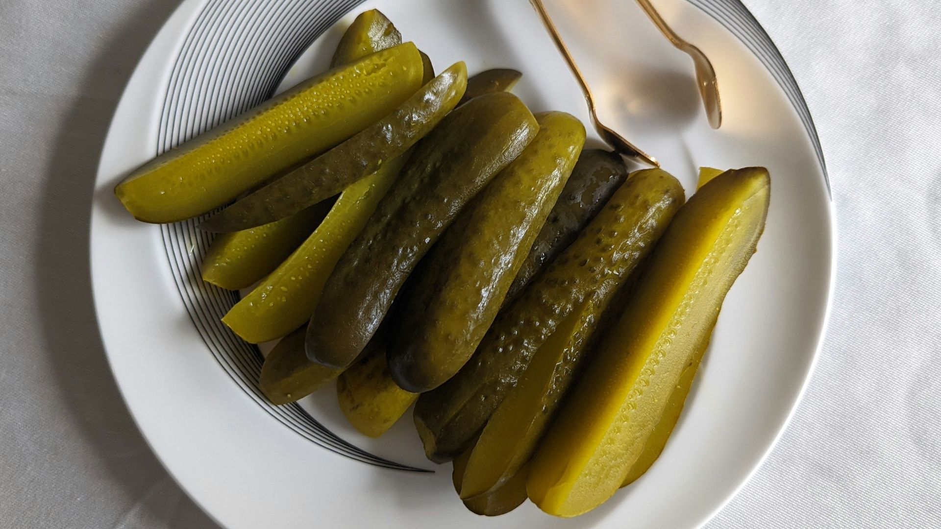 a white plate topped with pickles next to a fork