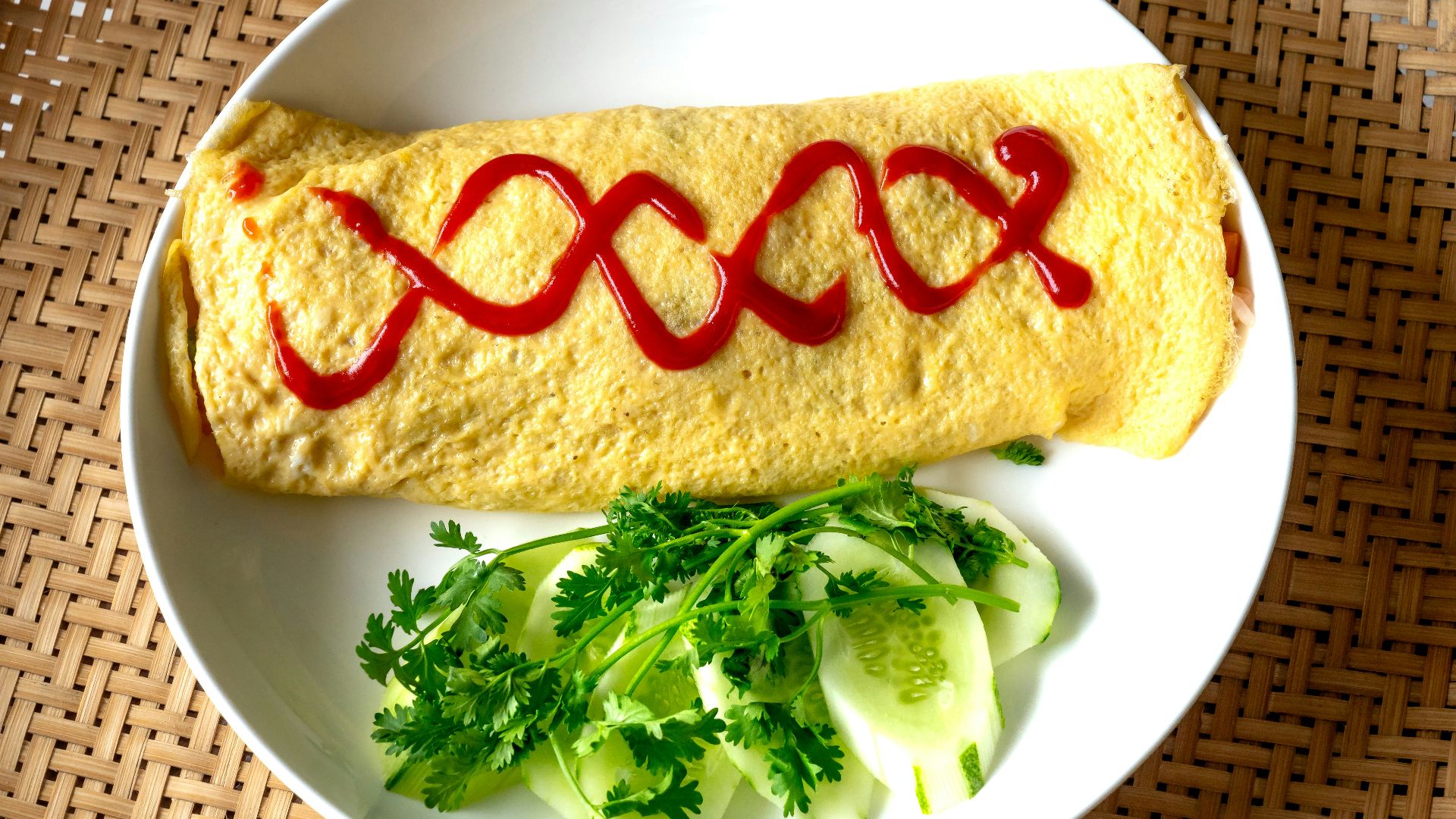 a white plate topped with an omelet covered in sauce