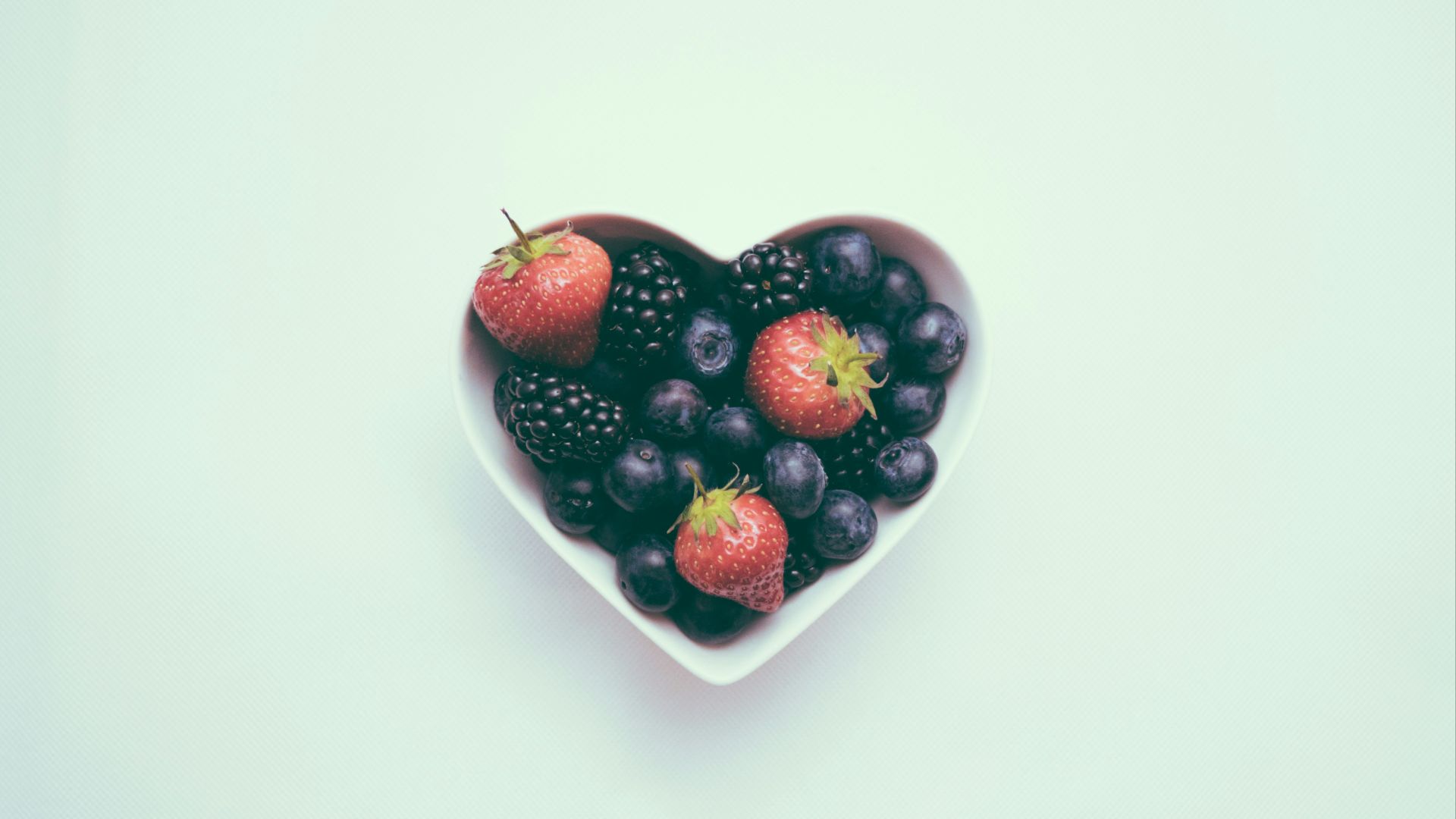 heart-shaped bowl with strawberries