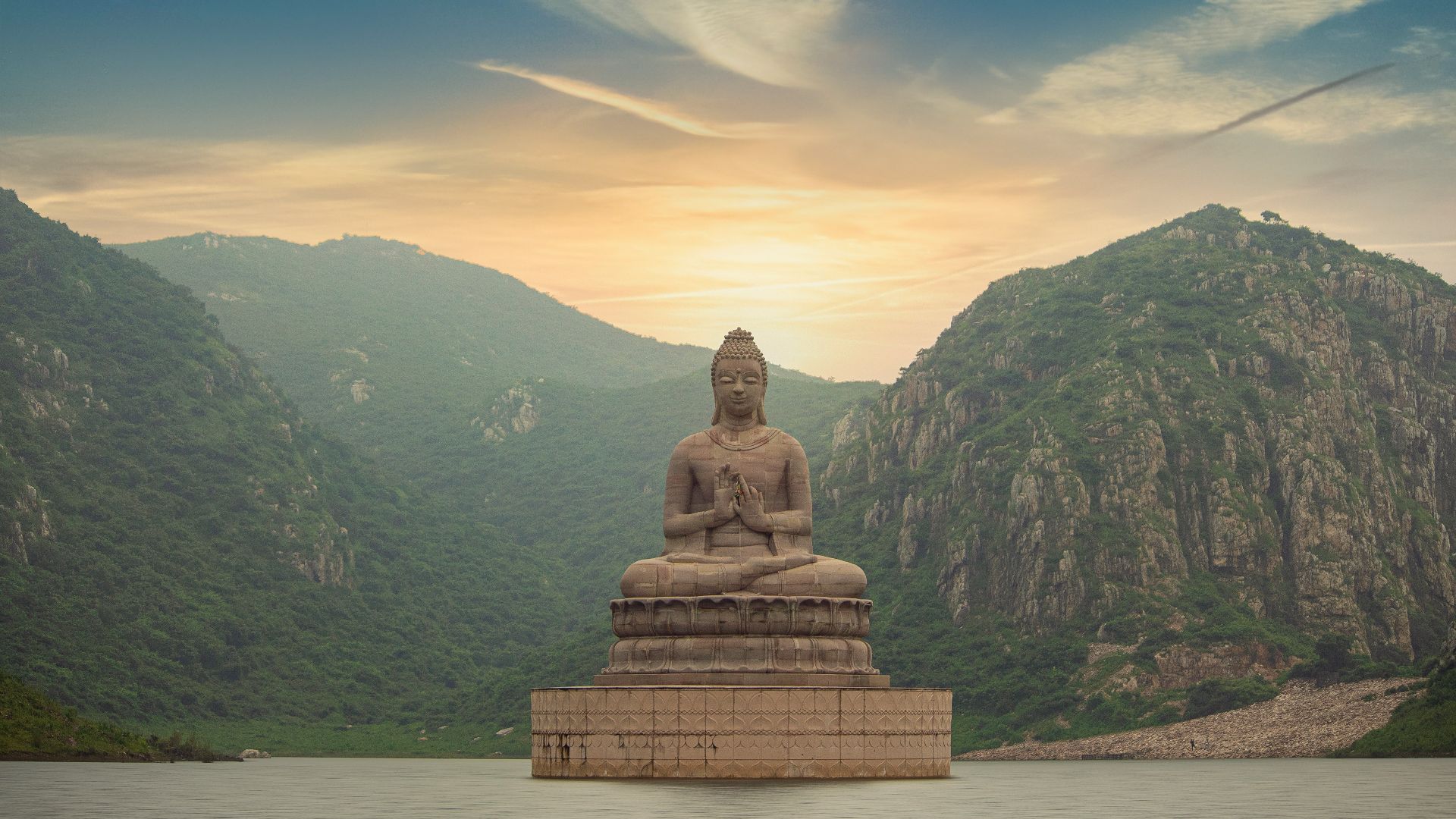 brown buddha statue near green mountain under blue sky during daytime