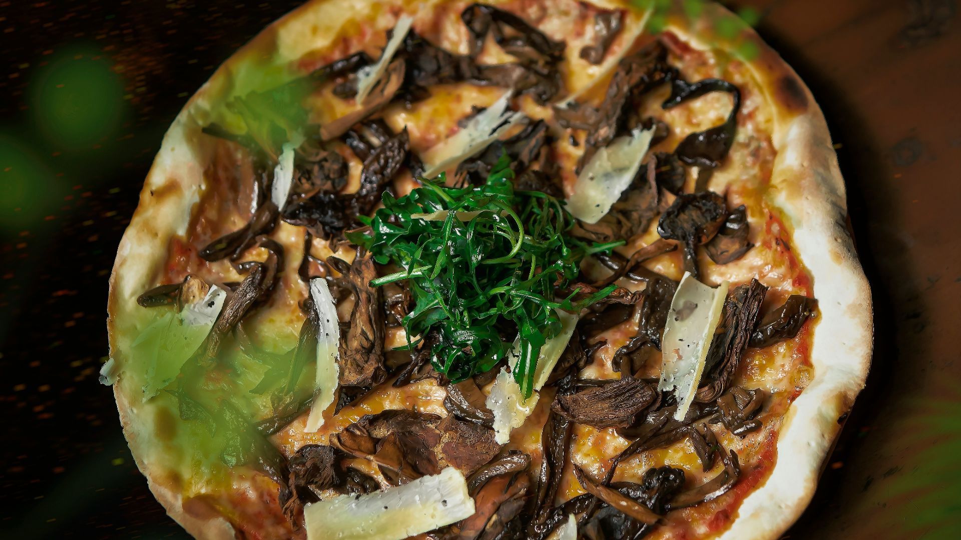 a pizza with mushrooms, cheese, and greens on it
