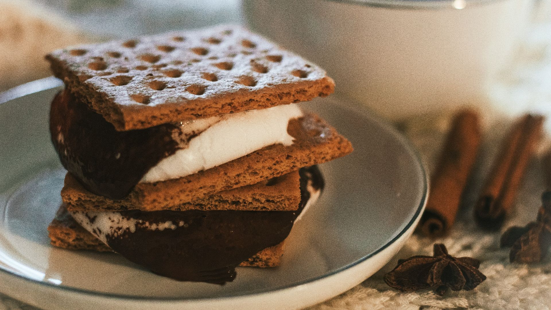 a stack of waffle sandwiches on a plate next to a cup of coffee