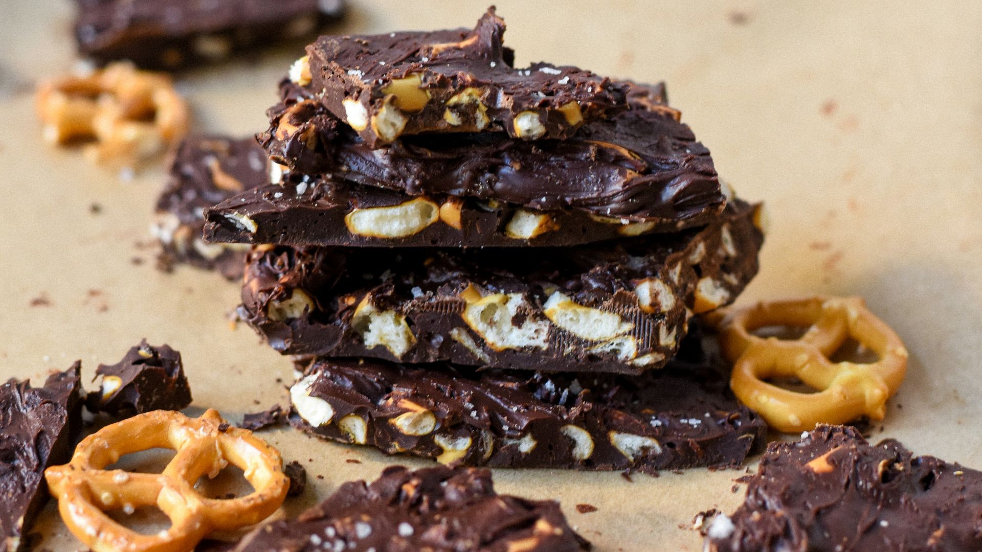 a pile of chocolate covered pretzels on top of a piece of parchment paper
