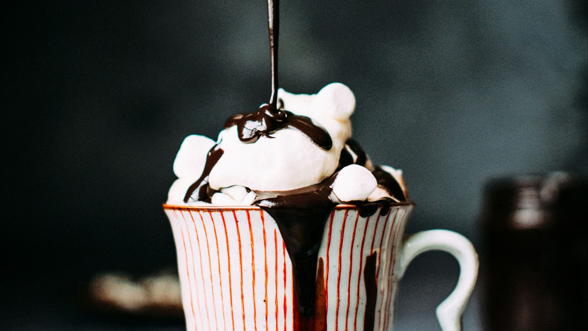 chocolate pouring on vanilla ice cream in ceramic cup