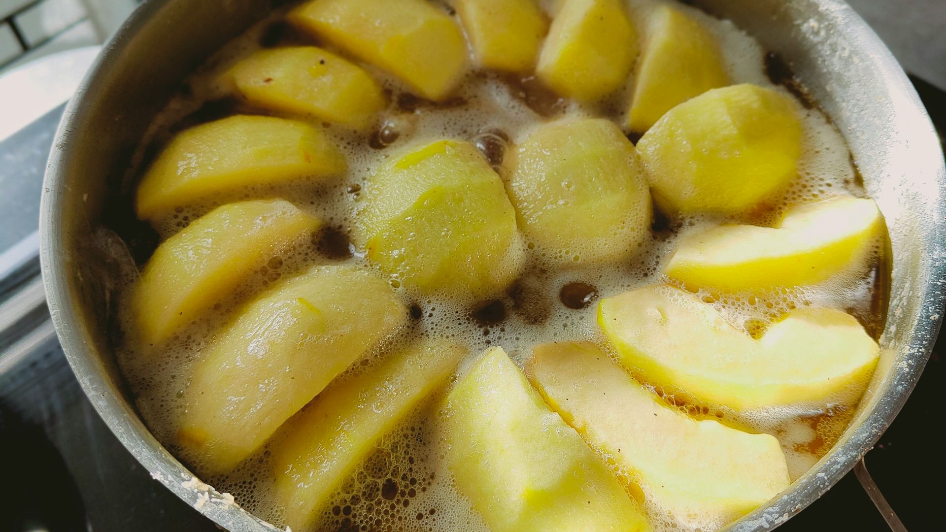 a pan filled with sliced apples on top of a stove