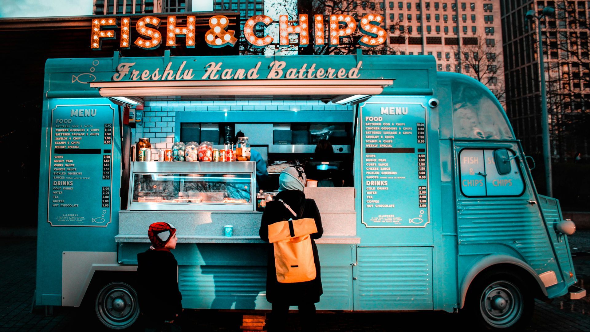 woman in brown coat standing in front of food stall