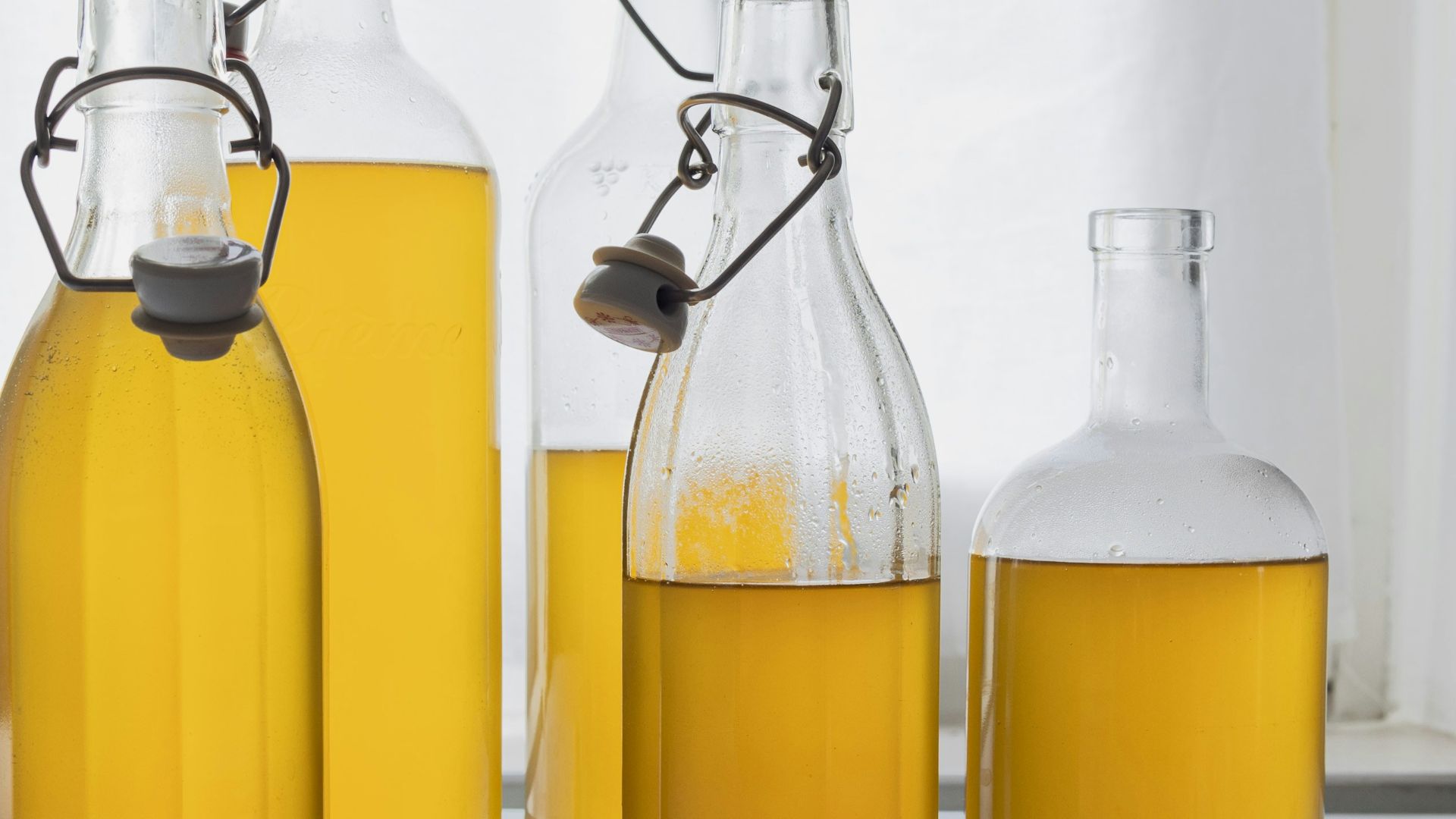 A group of bottles filled with yellow liquid