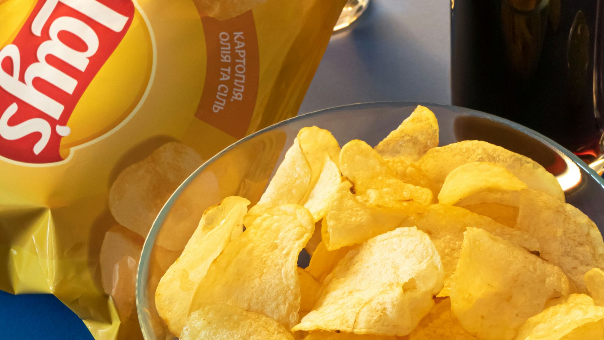 clear drinking glass beside brown bread on blue ceramic plate