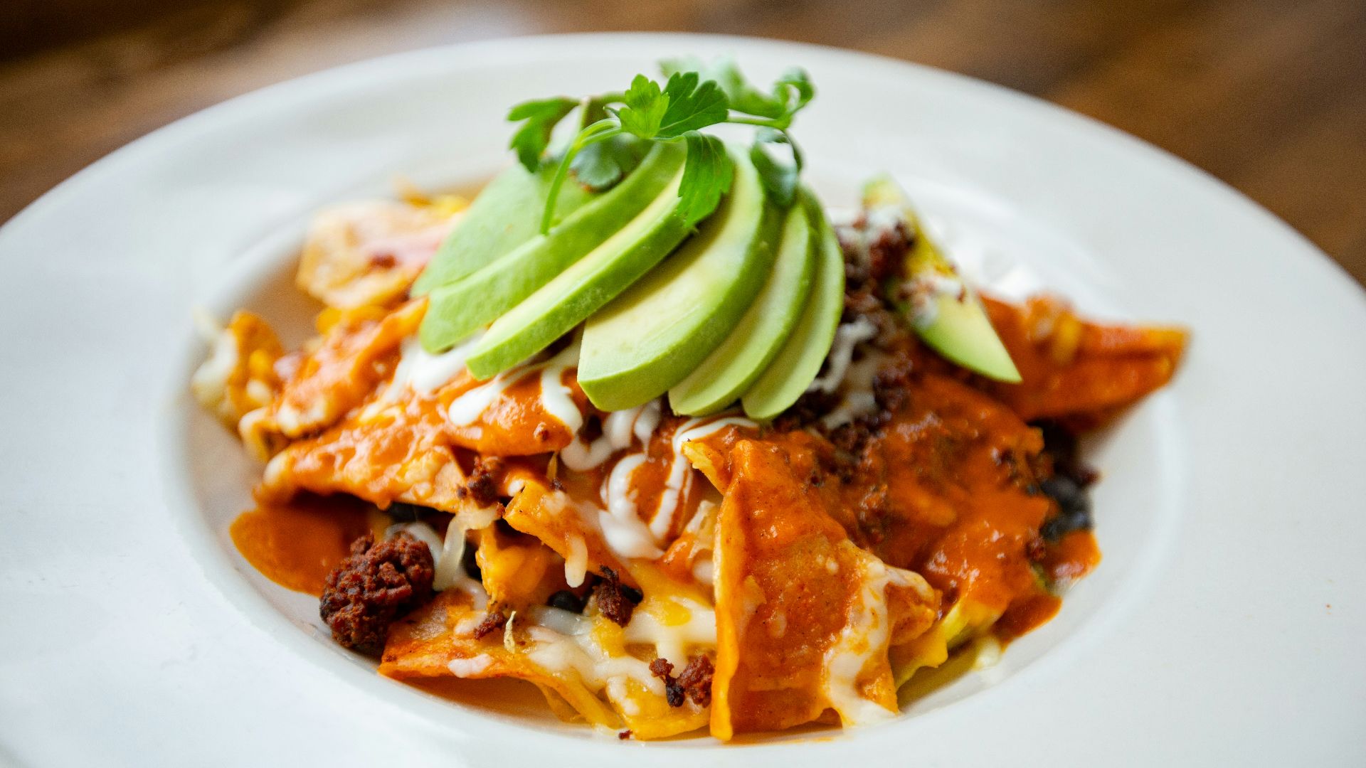a plate of mexican food with avocado on top