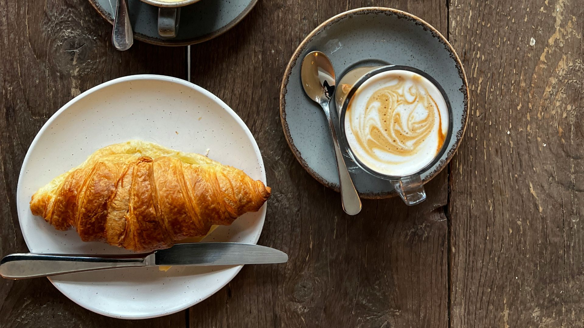 A table topped with plates of food and cups of coffee
