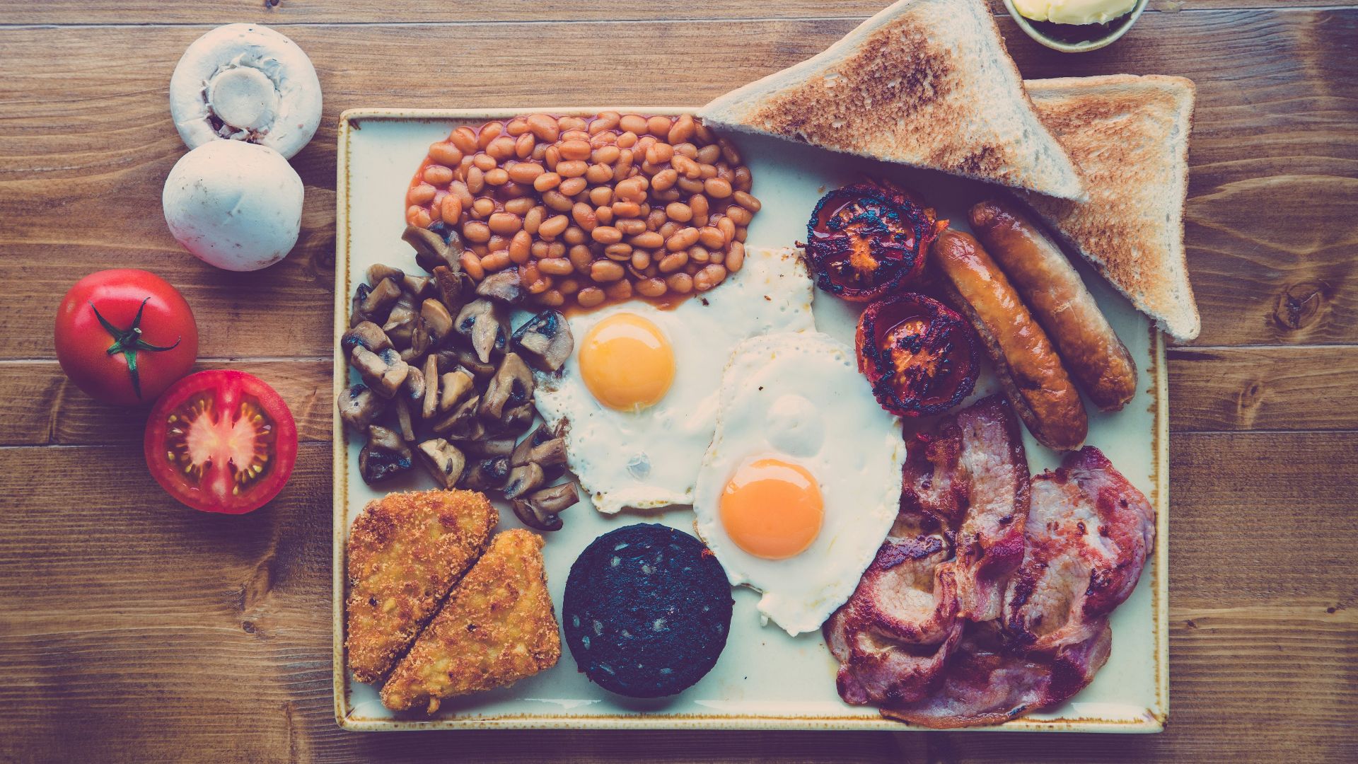 fried ham, egg, bread with beans and red tomato slice