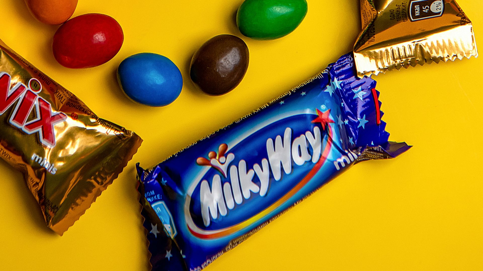 A variety of candy on a yellow background