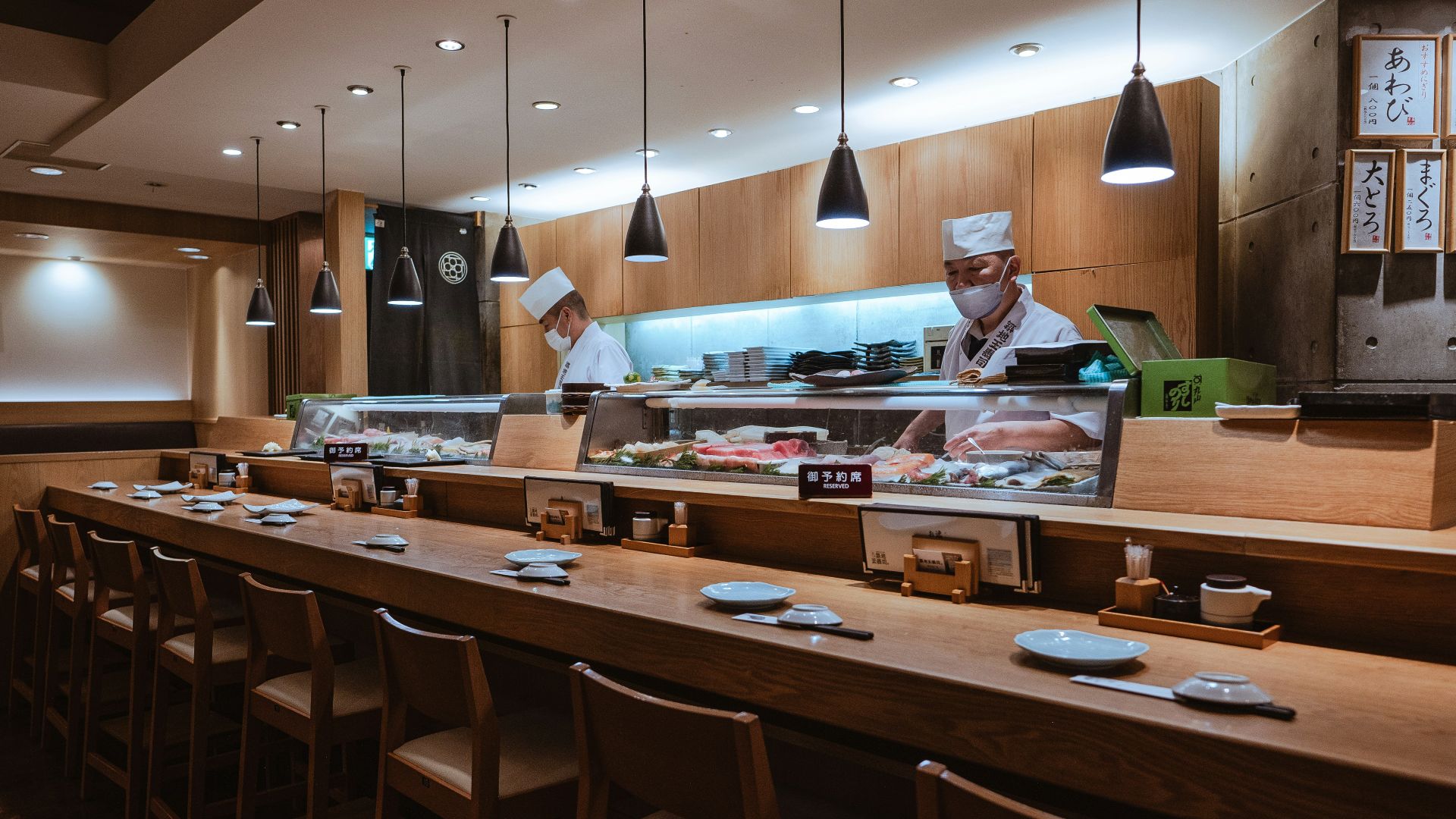 a restaurant with a long counter and a chef behind the counter