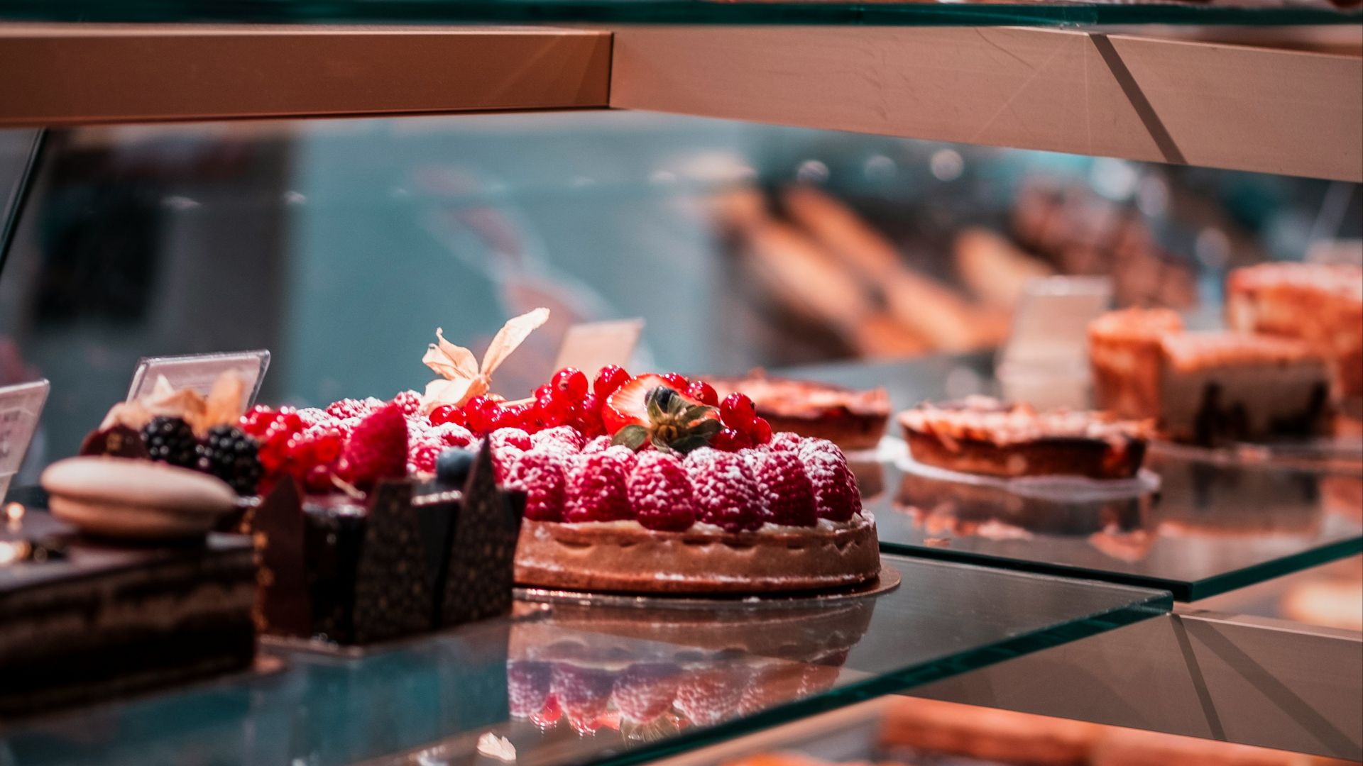strawberry and blackberry on clear glass display counter