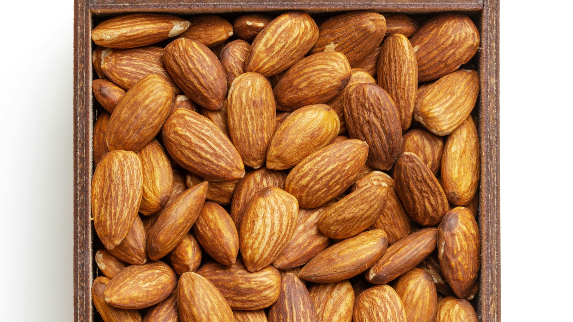 brown almond nuts on white surface