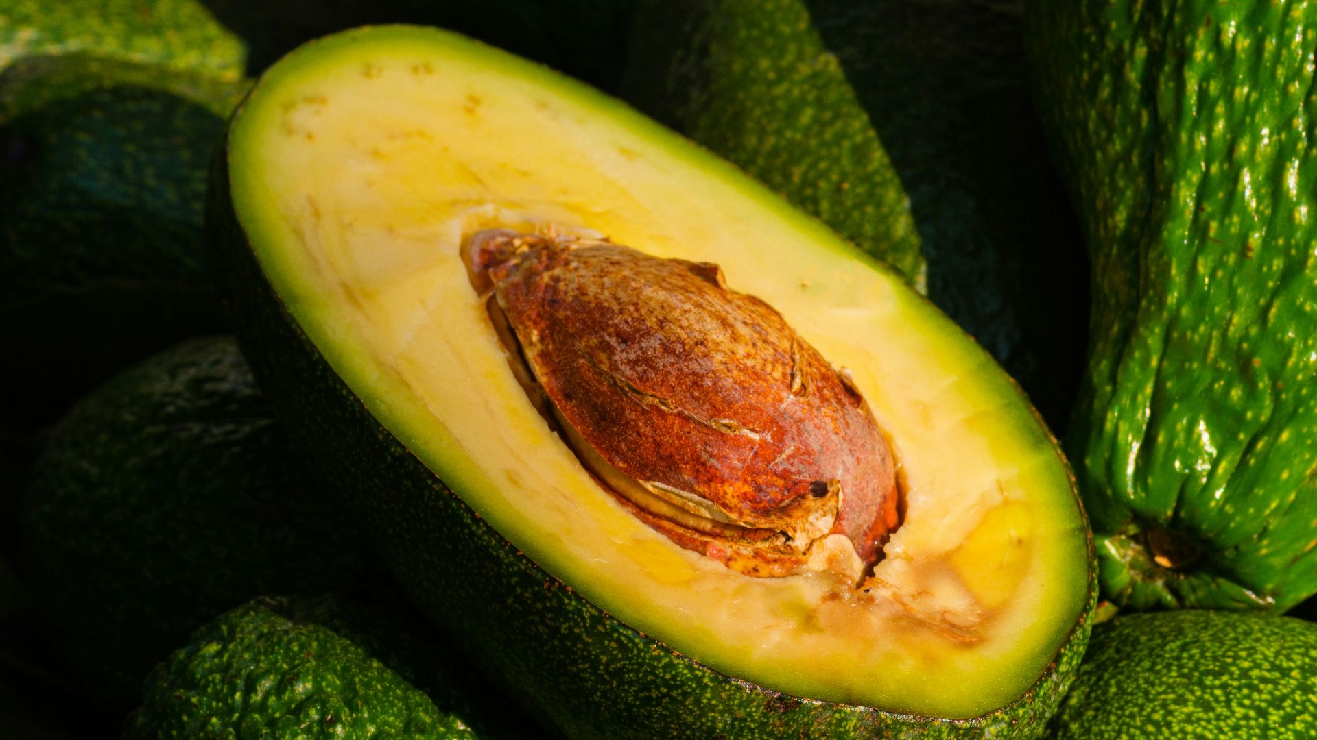 a pile of green avocados sitting on top of each other